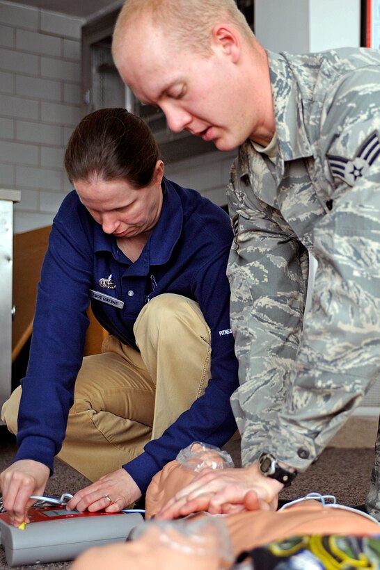ELLSWORTH AIR FORCE BASE, S.D. - (Right) Senior Airman Marc Lane, 28th Bomb Wing still photographic journeyman, performs chest compressions on a dummy while Tech. Sgt. Kathy Gatzke, 28th Force Support Squadron fitness center NCO in-charge, prepares an automated external defibrillator for use during a heart saver certification course, April 20. The course has various scenarios to reinforce the cardio pulmonary resuscitation and AED instructions. (U.S. Air Force photo/Airman 1st Class Matthew Flynn