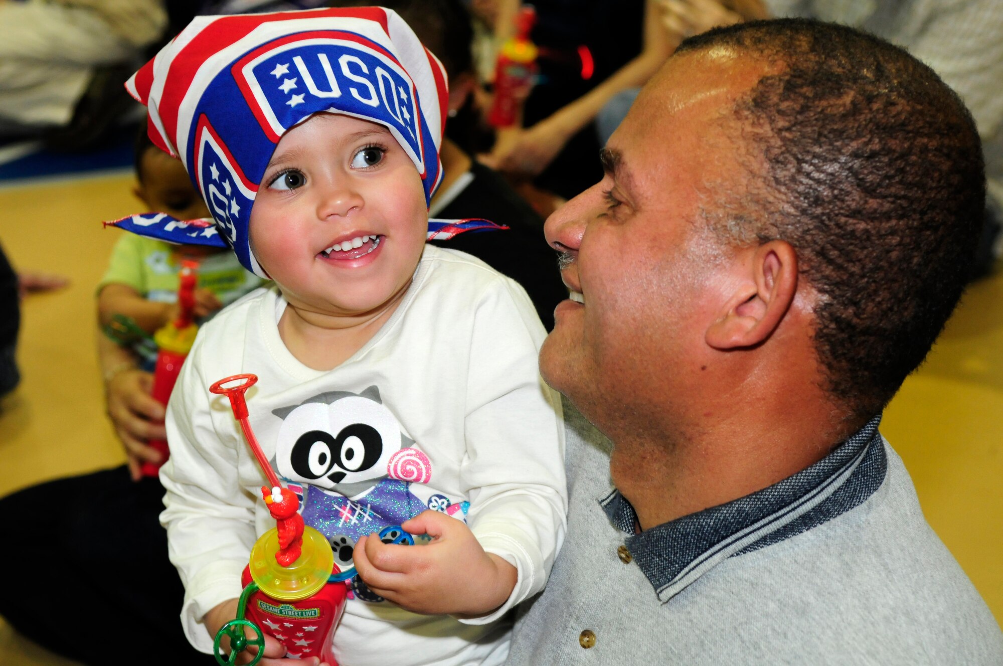 Retired Air Force Staff Sgt. Luis Falu and his daughter, Sarah, 2, watch  a Sesame Street production April 21 at the Bolling Youth Center. The USO-sponsored event is an outreach program focused on talking, listening, and connecting for military families and their children. (U.S. Air Force photo by Staff Sgt. Raymond Mills)