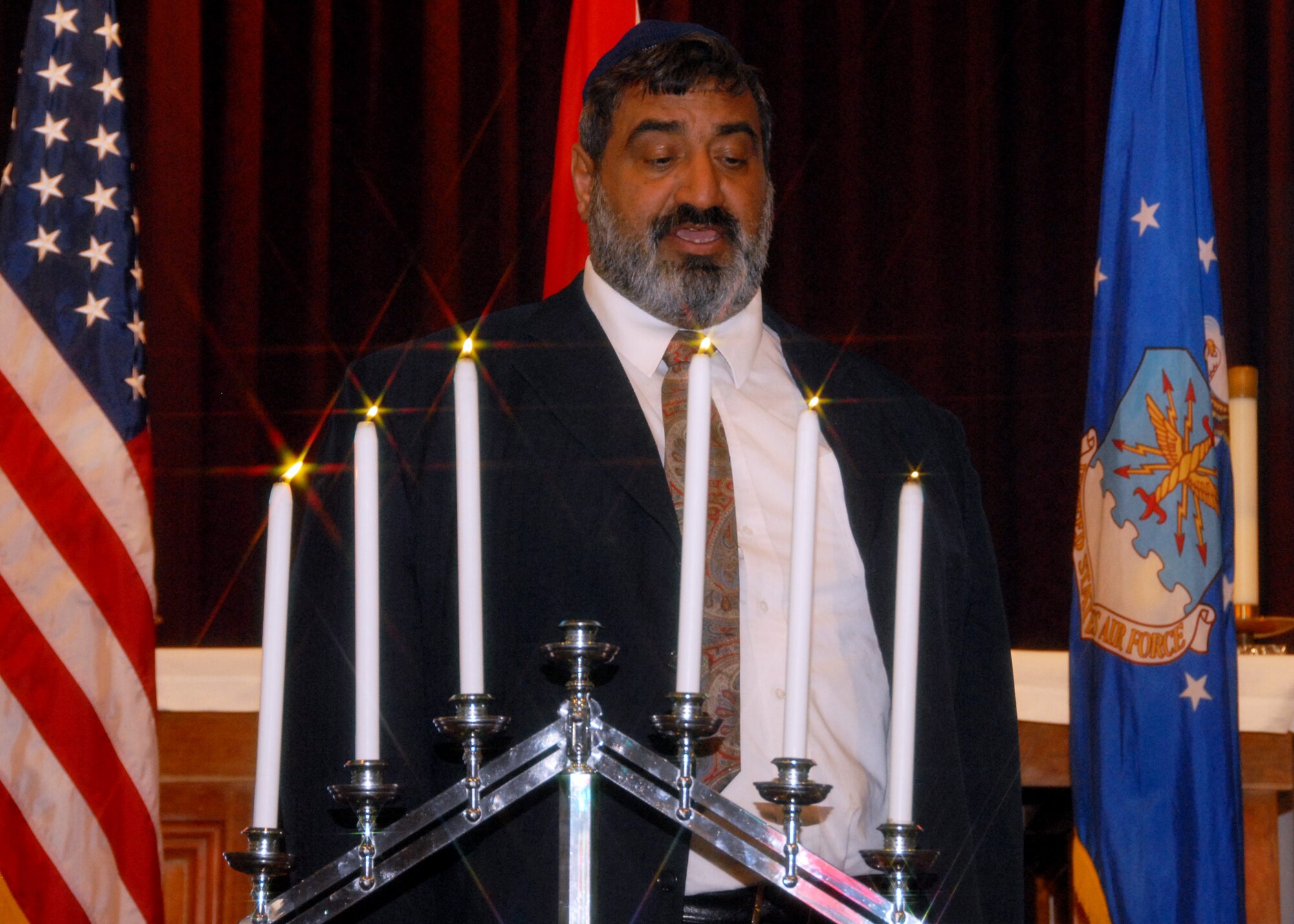 Rabbi Israel Vana, says a prayer over the menorah during the Day of Remembrance observance at Eglin Air Force Base, Fla., April 20.  The event took place three weeks prior the 65th anniversary of the end of World War II in Europe.  Guest speaker, Dr. Victor Sapio talked about his time spent in a Nazi concentration camp as a young boy.  Eventually, he and his mother moved to America where he learned to speak English and became a professor.  (U.S. Air Force photo/Samuel King Jr.) 