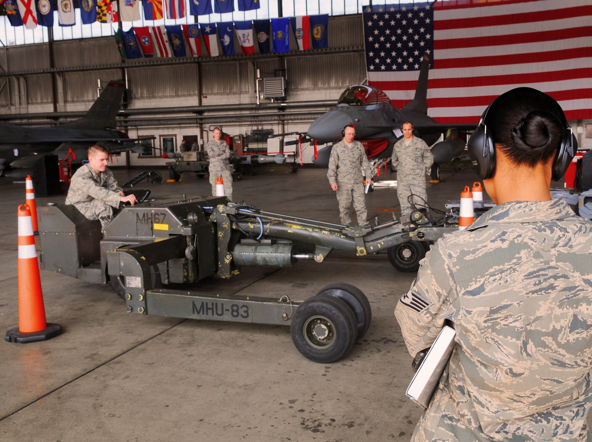 SPANGDAHLEM AIR BASE, Germany -- Evaluators observe Airman 1st Class Zachary Rubinstein, 52nd Aircraft Maintenance Squadron weapons load crew team member,  as he positions the MHU-83 jammer boom during the 52nd Fighter Wing Load Crew of the Quarter competition April 16. The MHU-83 jammer was chosen for the competition because of its challenging maneuverability as compared to other jammers. Airman Rubinstein bested two other Airmen and was crowned 52nd FW Jammer Driver of the Quarter. (U.S. Air Force photo/Airman 1st Class Nick Wilson)
