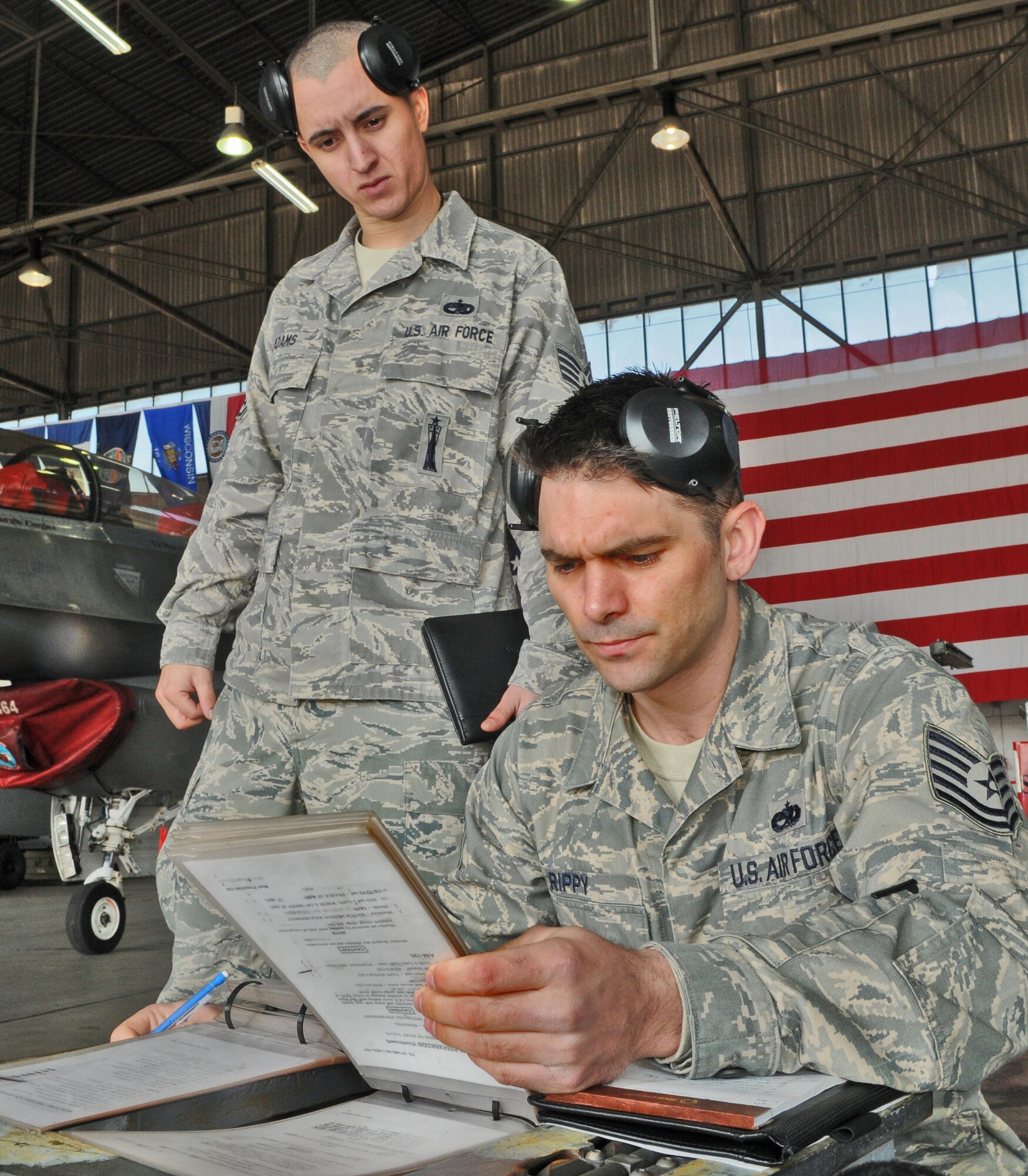 SPANGDAHLEM AIR BASE, Germany -- Tech. Sgt. James Rippy, right, 52nd Maintenance Operation Squadron loading standardization crew team member, references a procedural checklist for accuracy as Staff Sgt. Jonathon Adams, 52nd Aircraft Maintenance Squadron lead crew team member, watches over his shoulder during the  52nd Fighter Wing Load Crew of the Quarter competition April 16. The competition pitted three of the wing’s best load crews against each other to crown the best for the first quarter of 2010.  The competition consisted of a dress and appearance evaluation and composite tool-box inspection. (U.S. Air Force photo/Airman 1st Class Nick Wilson)