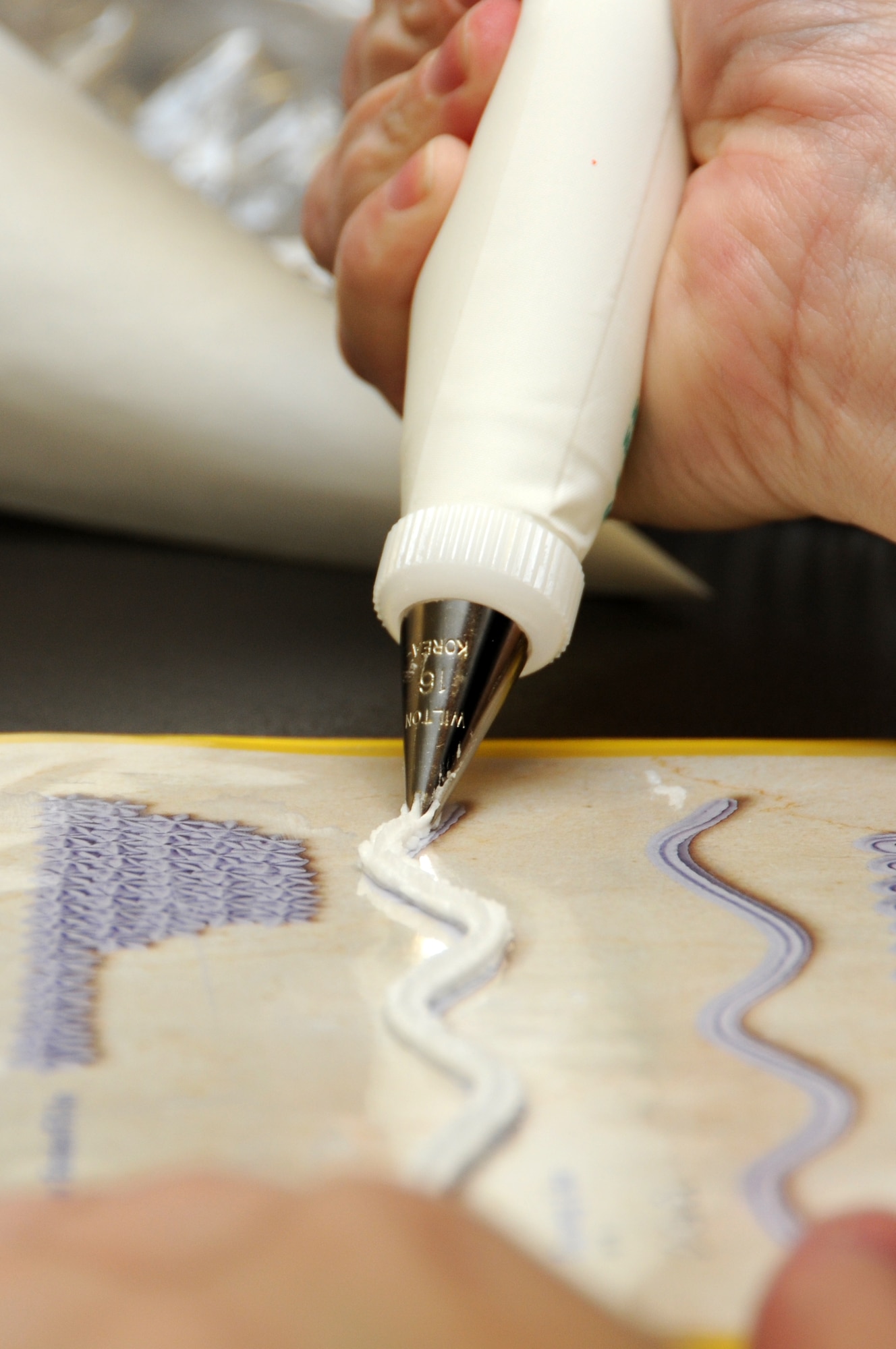Shown is an exercise to practice control when applying decorative icing. An icing bag is used to create and achieve many different decorating techniques to include borders, stars, and flowers. (U.S. Air Force photo by Airman 1st Class Lausanne Morgan)