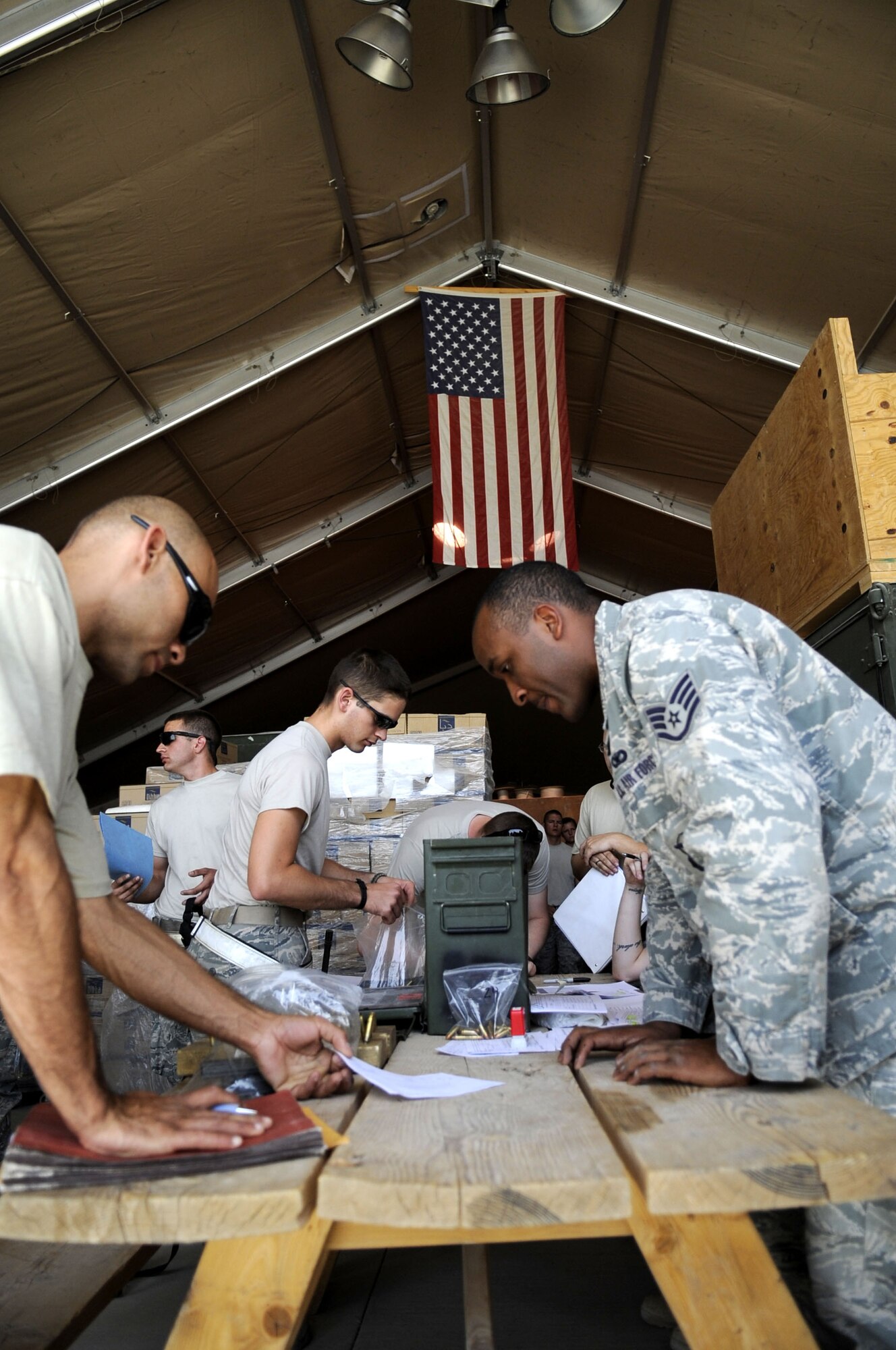 Staff Sgt. Chanson Johnson, 451st ESFS Combat Arms NCOIC, reviews a hand receipt to ensure redeploying members of the 451st Expeditionary Aircraft Maintenance Squadron have properly listed all items being turned in.  (U.S. Air Force photo by Senior Airman Nancy Hooks/Released)
