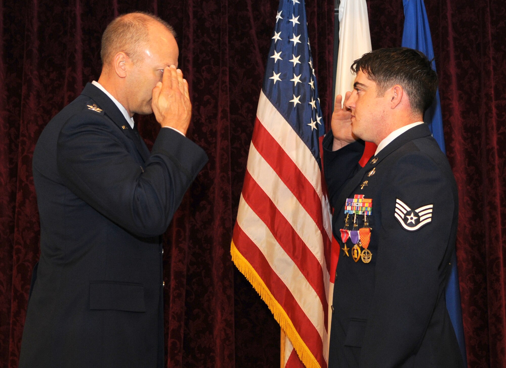 KADENA AIR BASE, Japan -- Staff Sgt. Jeremy King (right), a combat controller with the 320th Special Tactics Squadron, salutes Col. Robert Toth, the 353rd Special Operations Group commander, after receiving the Bronze Star, Purple Heart and Air Force Combat Action medals during a ceremony here April 16. Sergeant King earned the medals while deployed supporting operations in Afghanistan. (Photo by Tech. Sgt. Aaron Cram)
