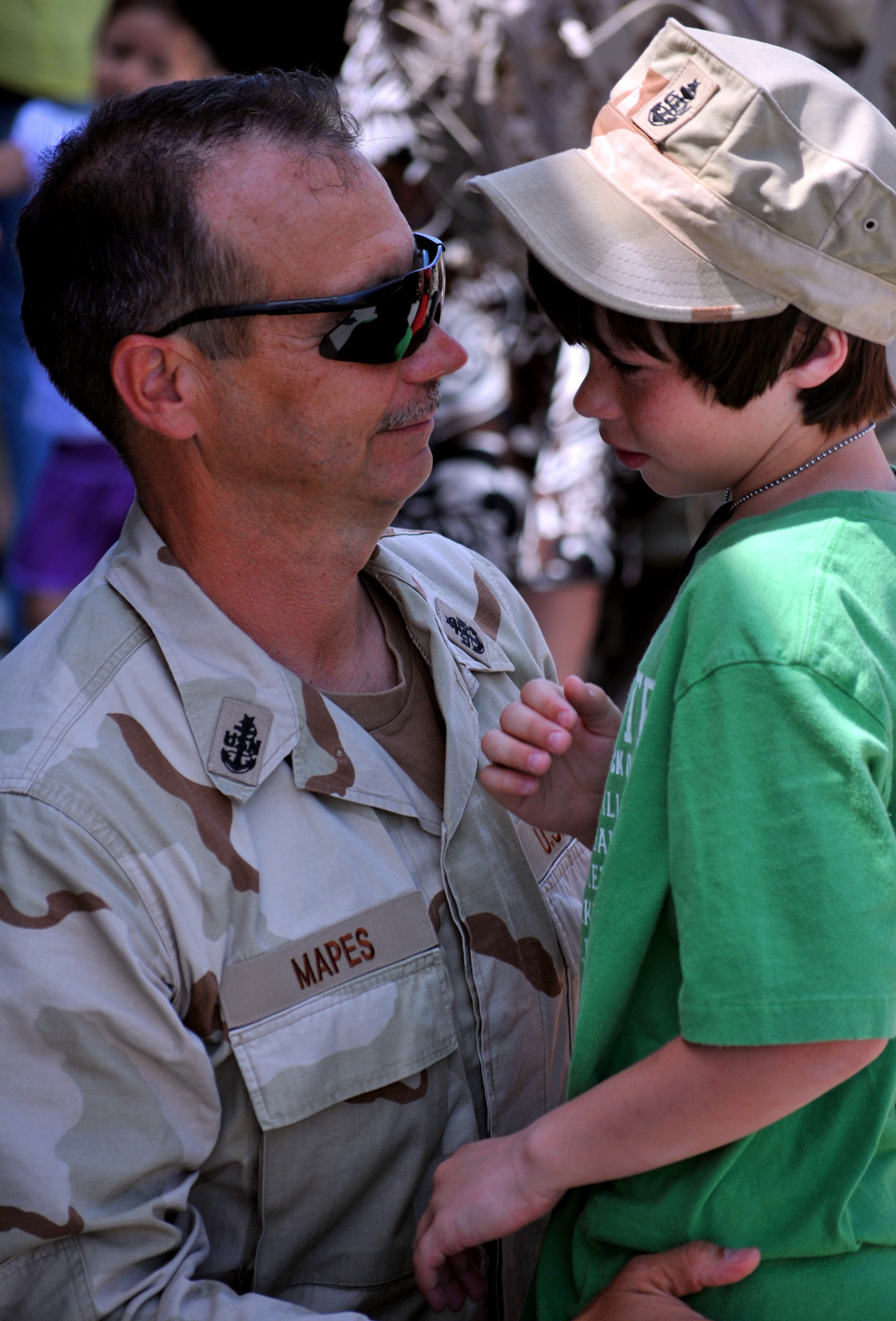 U.S. Navy Senior Chief Don Mapes hugs his son at the training hall at Naval Construction
