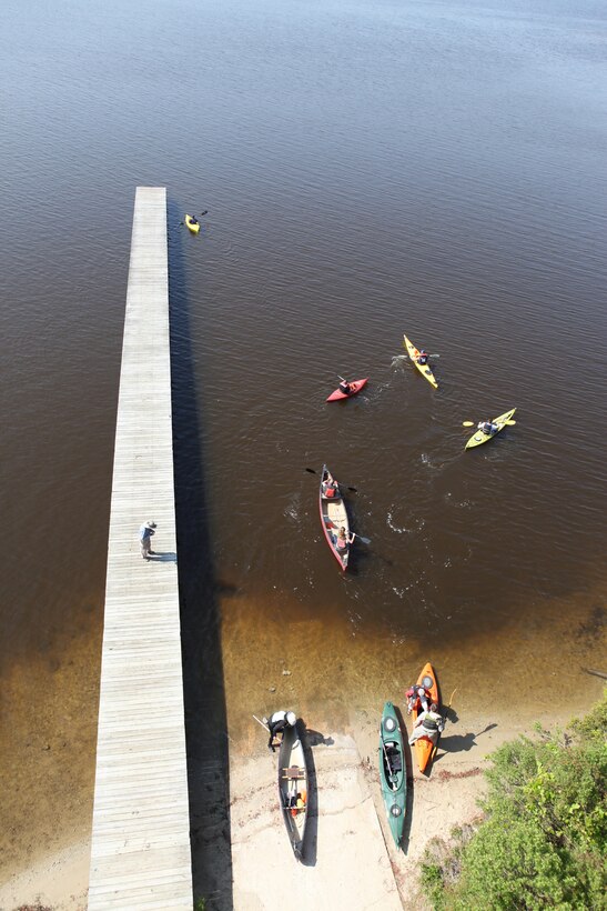 Volunteers from North Carolina and service members aboard Marine Corps Base Camp Lejeune, paddle kayaks and canoes on New River before picking up trash along the coastline, April 22.  These volunteers and service members picked up trash, tires and old toys in celebration of Earth Day.