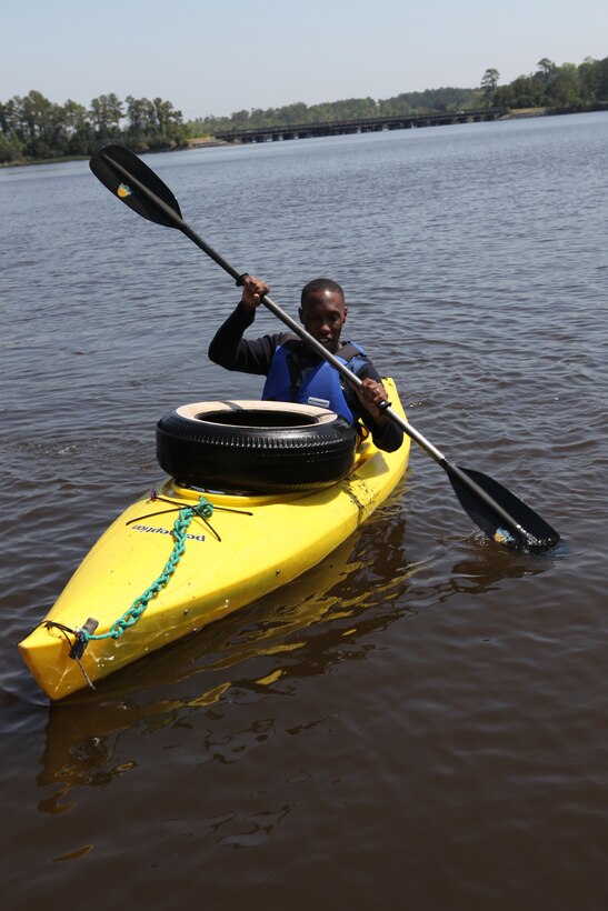 Lance Cpl. Donte Simmons, a postal clerk with Company I, Headquarters and Support Battalion, Marine Corps Base Camp Lejeune, travels with a big tire that he collected from the coastline on New River, April 22.  Volunteers from North Carolina and service members aboard Marine Corps Base Camp Lejeune, picked up trash, tires and old toys in celebration of Earth Day.