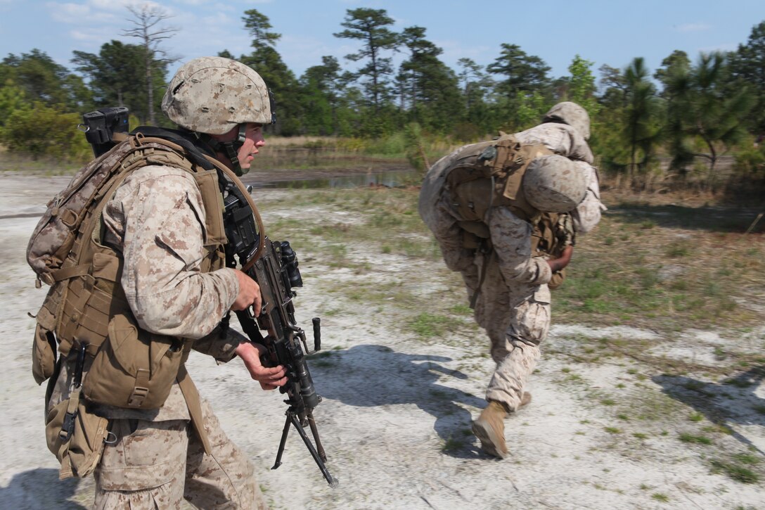 A Marine with Company K, Battalion Landing Team 3/8, 26th Marine Expeditionary Unit, provides security while another Marine carries a simulated casualty at Combat Town during the Motorized Raid Course aboard Camp Lejeune, N.C., April 22, 2010. The Motorized Raid Course is one of several Special Operations Training Group, II Marine Expeditionary Force, events as part of 26th MEU's preparation for deployment this  fall.
