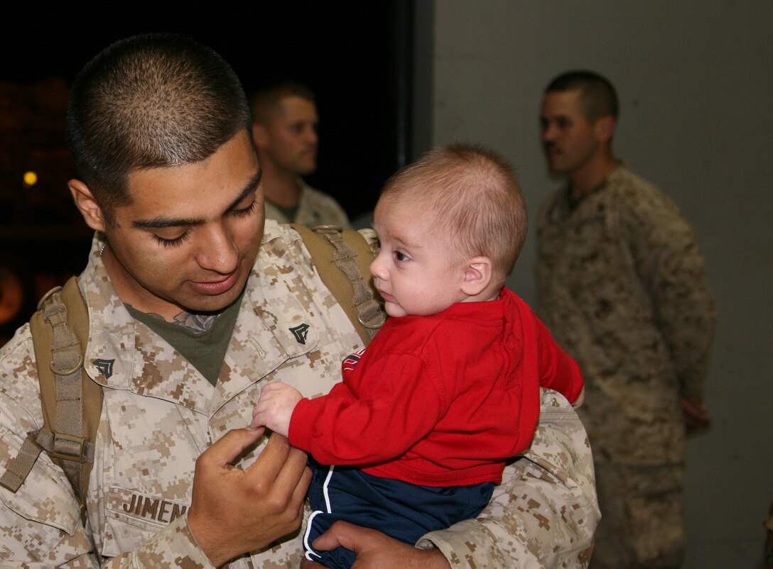 Cpl. Josue A. Jimenez holds his son after a six-month deployment to Afghanistan. Jimenez met his newborn child, Jaymes, for the first time, April 21. Jimenez is an aircraft communications/navigation/radar systems technician with VMAQ-1.