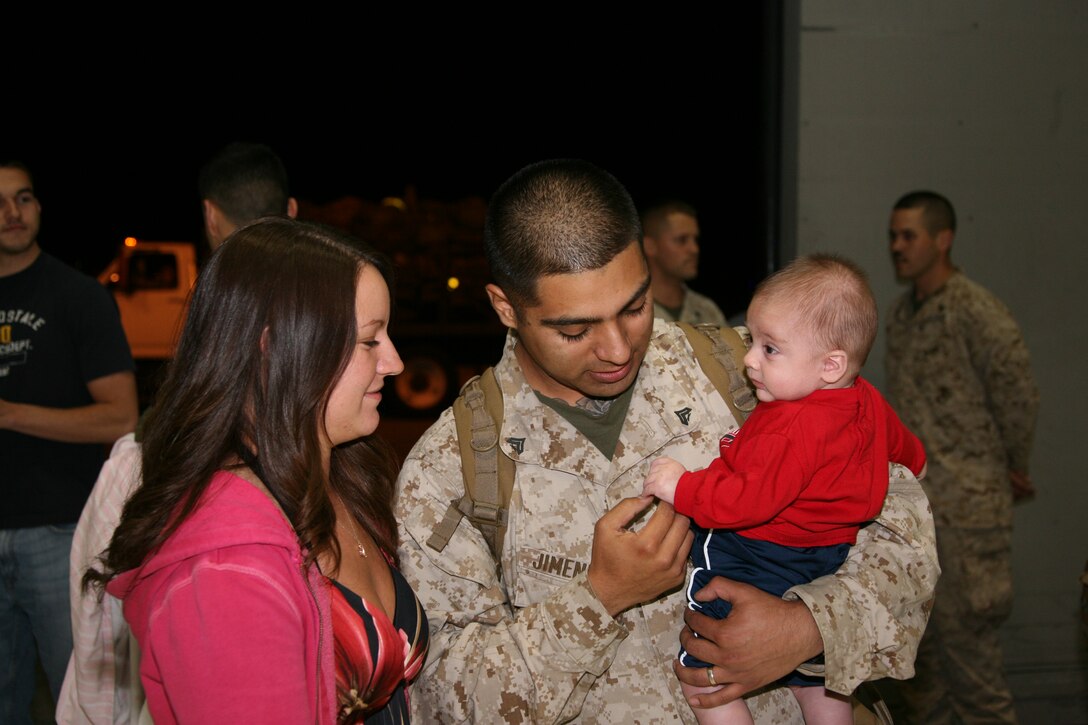 Cpl. Josue A. Jimenez holds his son after a six-month deployment to Afghanistan. Jimenez met his newborn child, Jaymes, for the first time, April 21. Jimenez is an aircraft communications/navigation/radar systems technician with VMAQ-1.