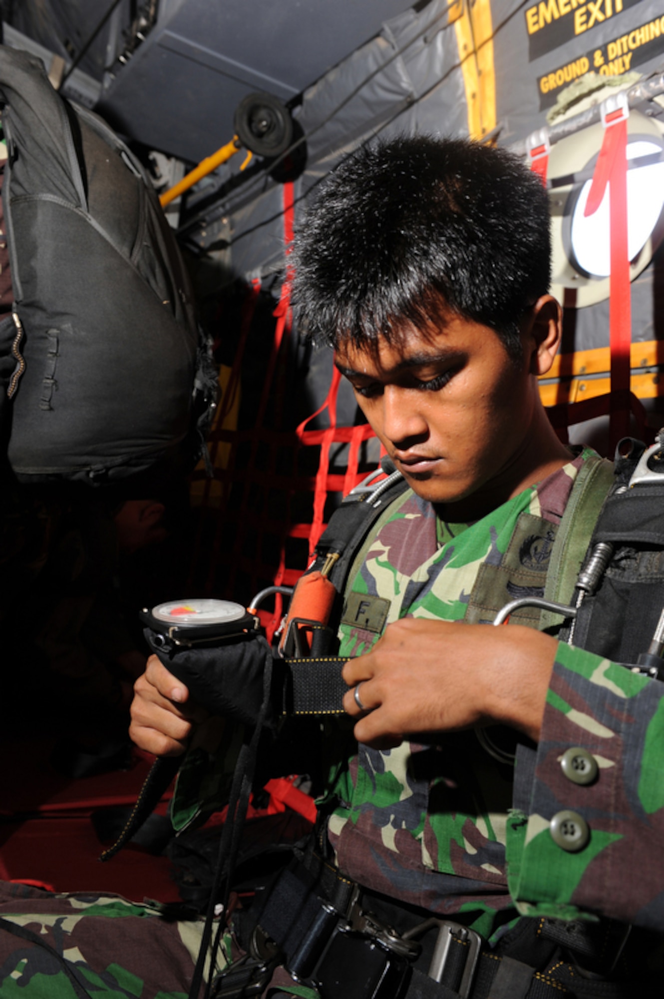 An Indonesian jumpmaster conducts a few last minute checks on his gear over the Gordo drop zone in Indonesia before jumping out of a C-130 Hercules from the 36th Airlift Squadron out of Yokota Air Base, Japan, on April 22, 2010.  U.S. and Indonesian airmen are participating in Cope West 10, a Pacific Air Forces-sponsored bilateral tactical airlift exercise involving the U.S. and Indonesian air forces. The exercise is designed to advance interoperability between the two services, and promote cooperation and unity of purpose.  (U.S. Air Force photo/Tech. Sgt. Cohen A. Young)