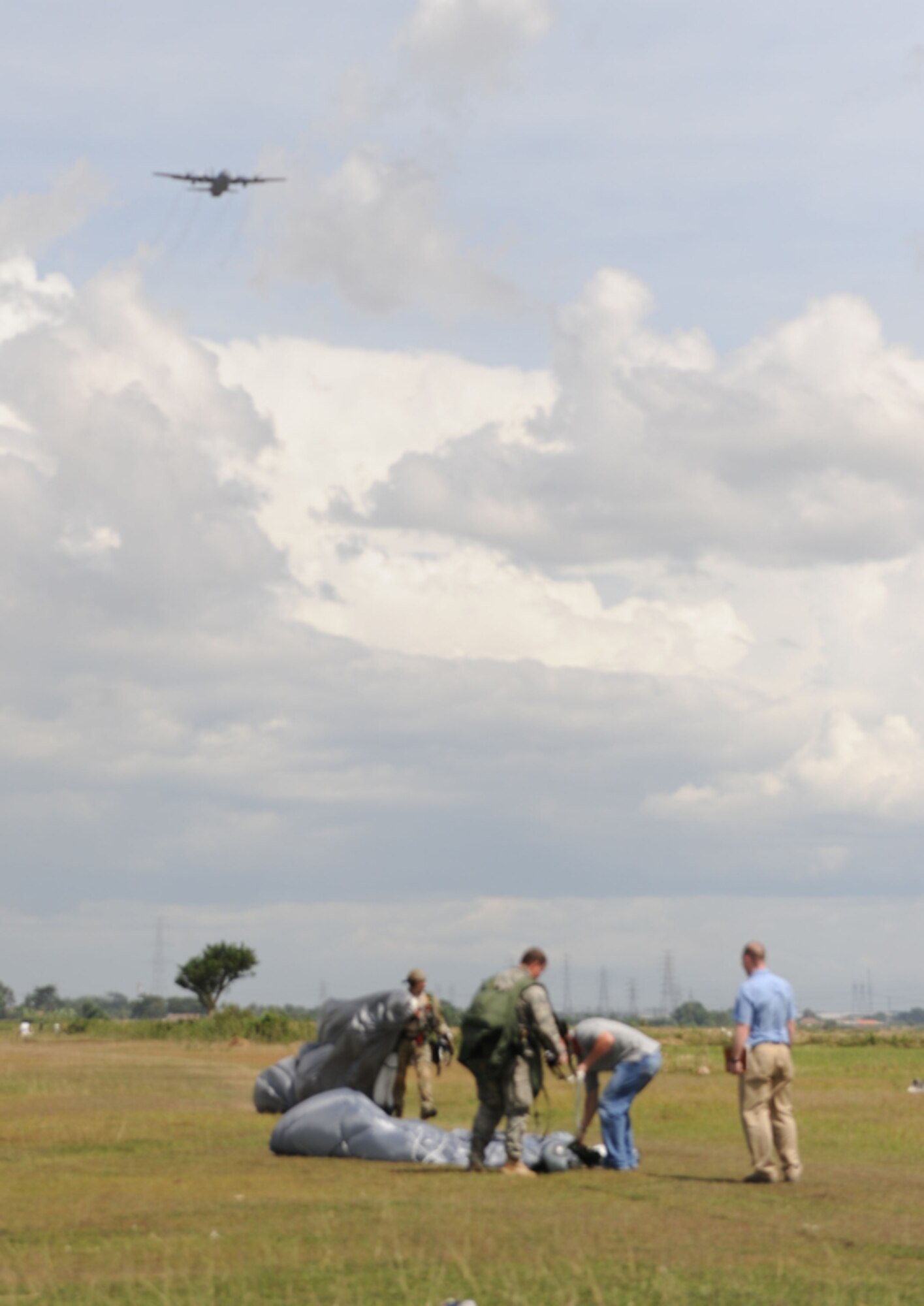 U.S. Air Force jumpmasters gather their parachutes after conducting high-altitude, low-opening jumps  over the Gorda drop zone in Indonesia during exercise Cope West 10 in Indonesia, April 21, 2010. Cope West is a Pacific Air Forces-sponsored bilateral tactical airlift exercise involving U.S. and Indonesian air forces. The exercise is designed to advance interoperability between U.S. and Indonesian air forces, and promote cooperation and unity of purpose.  (U.S.  Air Force photo/Tech Sgt. Cohen A. Young)