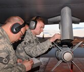 Staff Sgt. Adam Hatch, weapons load crewchief, reviews a technical order checklist while Senior Airman Troy Bledsoe, weapons load crewmember, secures an inert Joint Direct Attack Munition GBU-38 to an F-16 Fighting Falcon during Red Flag-Alaska April 19 at Eielson Air Force Base, Alaska. Both Airmen are deployed from the 8th Fighter Wing, Kunsan Air Base, Republic of Korea, and assigned to the 8th Aircraft Maintenance Squadron's 80th Aircraft Maintenance Unit Juvats. Red Flag-Alaska is a Pacific Air Forces-directed field training exercise for U.S. and coalition forces under simulated combat conditions. (U.S. Air Force photo/Capt. Shannon Collins) 