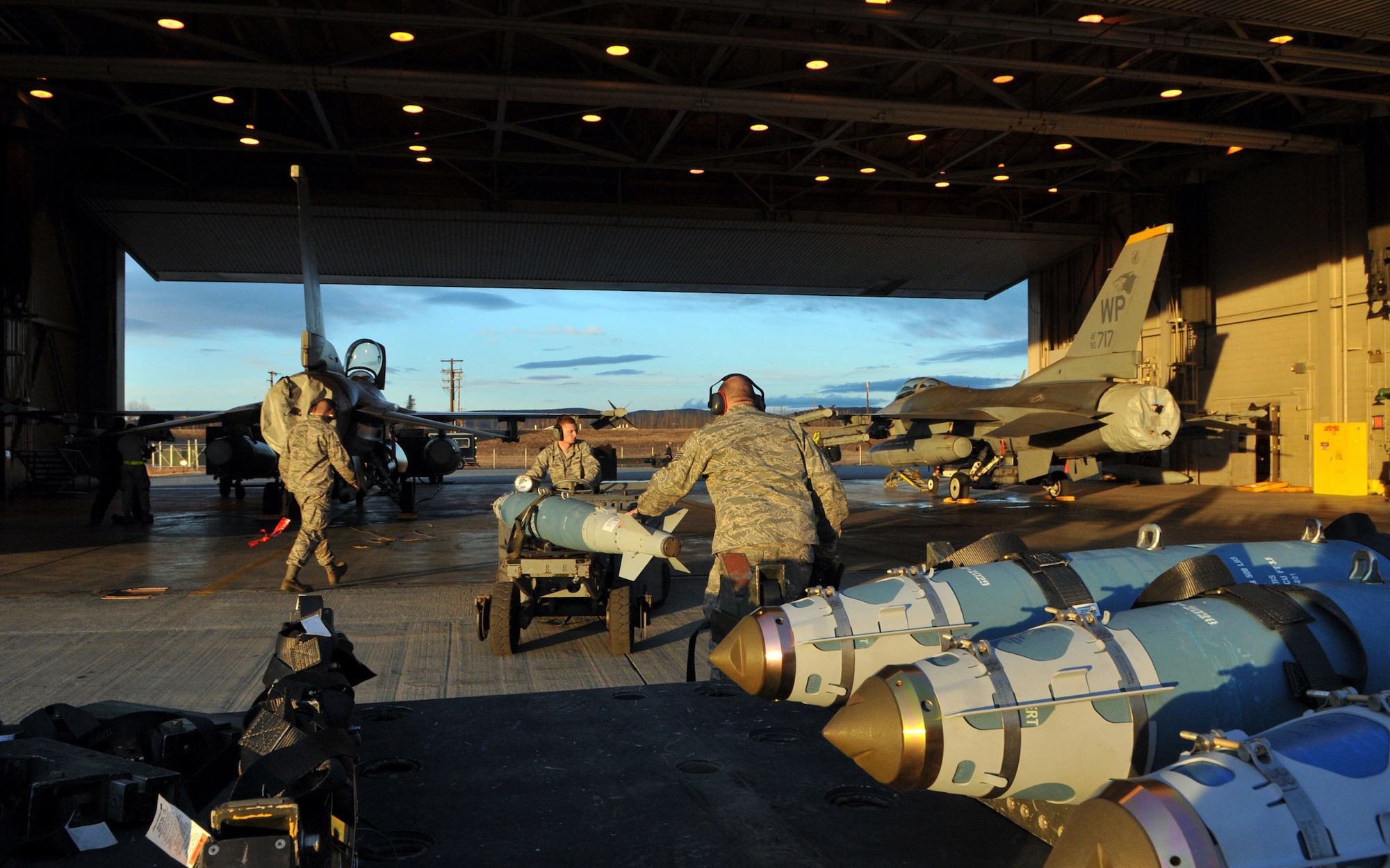 Airman Jon Casebolt and Senior Airman Troy Bledsoe, weapons load crewmembers, and Staff Sgt. Adam Hatch, weapons load crewchief, all assigned to the 8th Aircraft Maintenance Squadron's 80th Aircraft Maintenance Unit, use a jammer to move an inert Joint Direct Attack Munition GBU-38 to an F-16 Fighting Falcon during Red Flag-Alaska April 19 at Eielson Air Force Base, Alaska. All of the Airmen are deployed from the 8th Fighter Wing, Kunsan Air Base, Republic of Korea. Red Flag-Alaska is a Pacific Air Forces-directed field training exercise for U.S. and coalition forces under simulated combat conditions. (U.S. Air Force photo/Capt. Shannon Collins) 