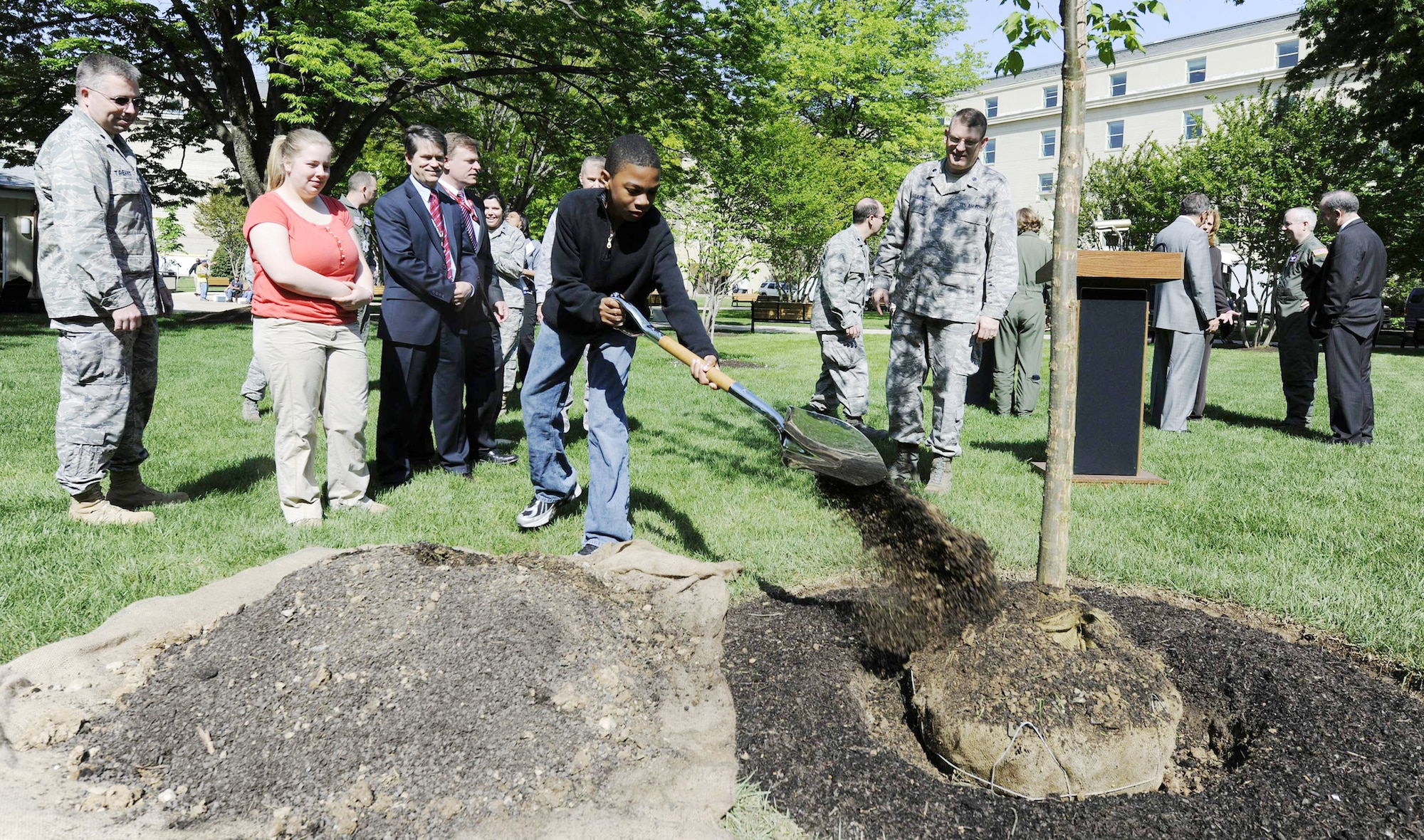 Thirteen-year-old Deante Dowdell, son of Maj. Richelle Dowdell, shovels soils onto a Valley Forge American elm as part of "40 Trees in 40 Communities" April 22, 2010, at the Pentagon. (U.S. Air Force photo/Scott Ash)