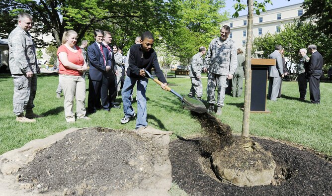 Thirteen-year-old Deante Dowdell, son of Maj. Richelle Dowdell, shovels soils onto a Valley Forge American elm as part of "40 Trees in 40 Communities" April 22, 2010, at the Pentagon. (U.S. Air Force photo/Scott Ash)