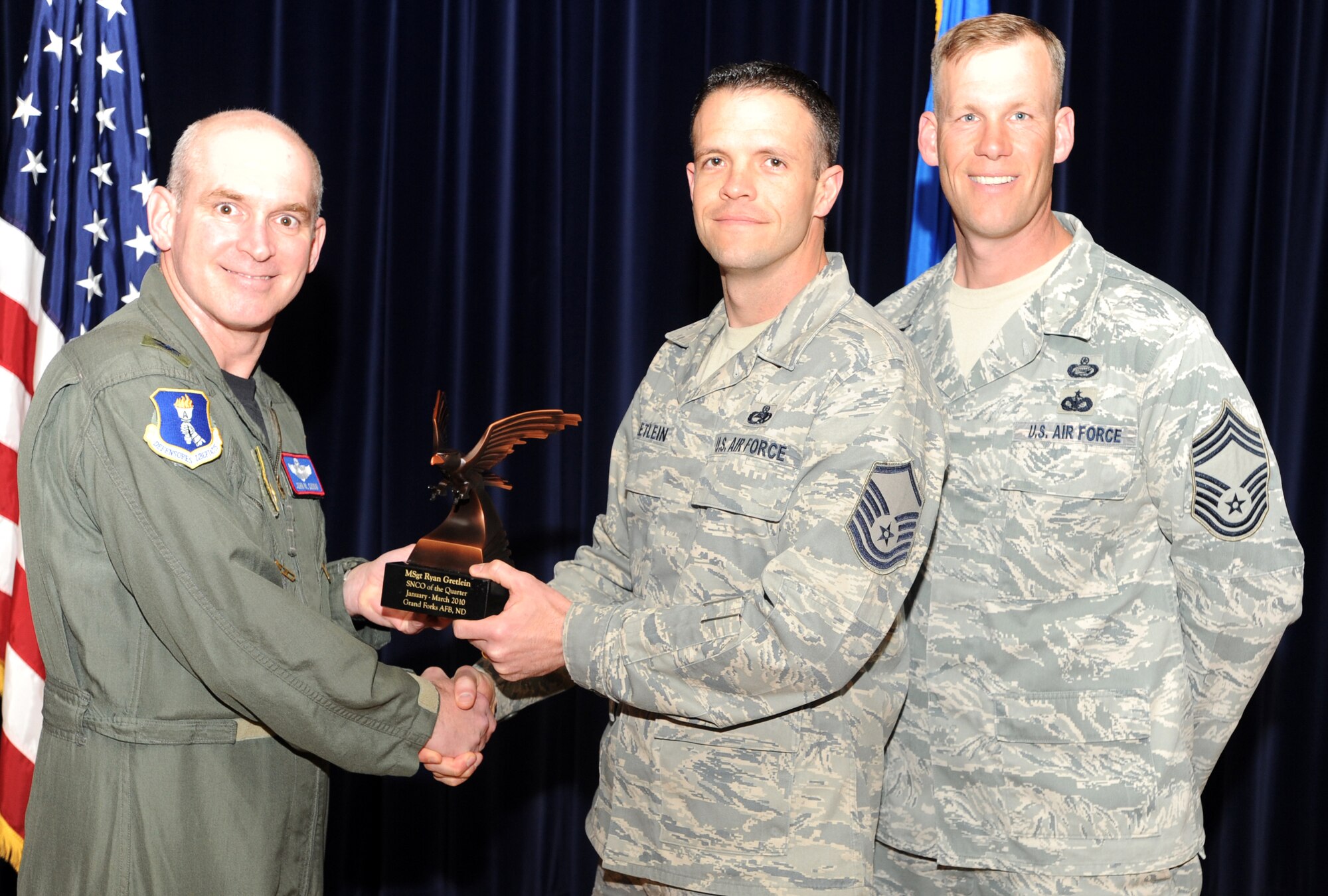 Master Sgt. Ryan Gretlein, 319th Aircraft Maintenance Squadron receives the Senior Non-commissioned Officer of the Quarter award from Col. John Quinn, 319th Air Refueling Wing vice-commander and Chief David Carlson, 319th ARW acting command chief during the 319 ARW Quarterly Awards at the base theater, April 15. Military and civilian nominees are selected on the basis of leadership and job performance in primary duties, significant self-improvement, and base and community involvement. (U.S. Air Force photo by Staff Sgt. Suellyn Nuckolls)