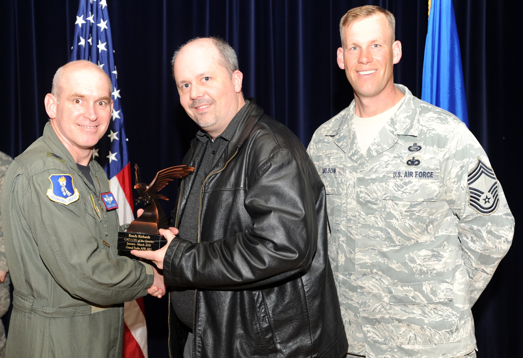 Randy Richards, a civilian with the 319th Aircraft Maintenance Squadron, receives the Category One Civilian award from Col. John Quinn, 319th Air Refueling Wing vice-commander and Chief David Carlson, 319 ARW acting command chief during the 319 ARW Quarterly Awards at the base theater, April 15. Military and civilian nominees are selected on the basis of leadership and job performance in primary duties, significant self-improvement, and base and community involvement. (U.S. Air Force photo by Staff Sgt. Suellyn Nuckolls)
