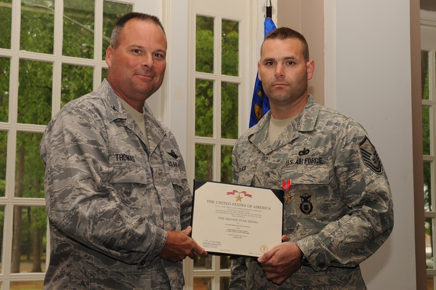 SEYMOUR JOHNSON AIR FORCE BASE, N.C. -- Col. William Thomas presents a Bronze Star award to Master Sgt. Kurt Black on April 21, 2010. Sergeant Black received this award for exemplary leadership, personal endeavor and devotion to duty from April 23 to October 23, 2009, at Ali Base, Iraq. Col. Thomas is the commander of the 4th Mission Support Group here and a native of Huntington Beach, Calif., Sergeant Black is the 4th Security Forces Squadron NCOIC of operations support here and hails from Bristol, Conn. (U.S. Air Force photo/Senior Airman Whitney Lambert)