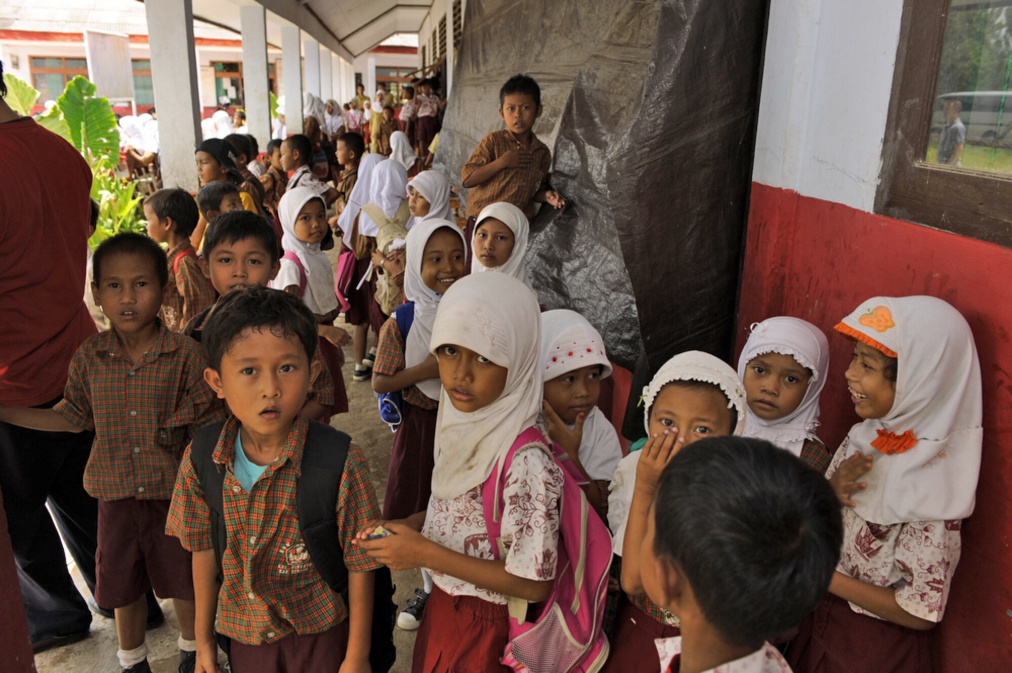 Indonesian children from a local elementary school greet Airmen from Yokota Air Base, Japan, as they arrive to donate more than 1,200 pounds of clothes, toys and sports equipment April 21, 2010, in Lanud Gorda Binuang, Indonesia. (U.S. Air Force photo/Tech. Sgt. Cohen A. Young)
