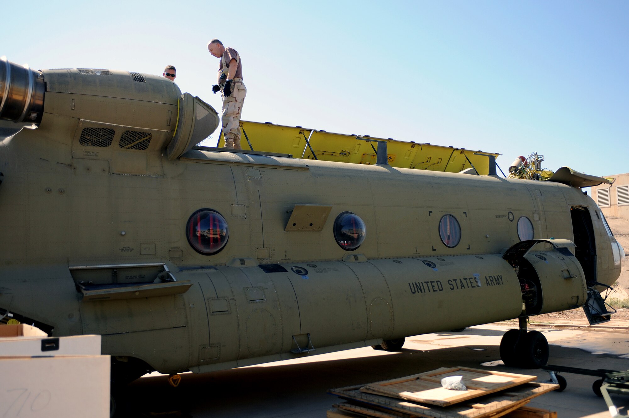 Petty Officer 1st Class Tommy Burnett, a Navy Customs inspector, has Army personnel open the top panel of a CH-47 Chinook helicopter to ensure cleanliness at Joint Base Balad, Iraq, April 15, 2010. Customs personnel inspected 28 helicopters consisting of AH-64 Apaches, Chinooks and UH-60 Black Hawks, to ensure they are clean and contain authorized equipment. The helicopters arrived from forward operating bases throughout Iraq and are being prepared for redeployment back to the United States. (U.S. Air Force photo by Master Sgt. Linda C. Miller/Released)   
