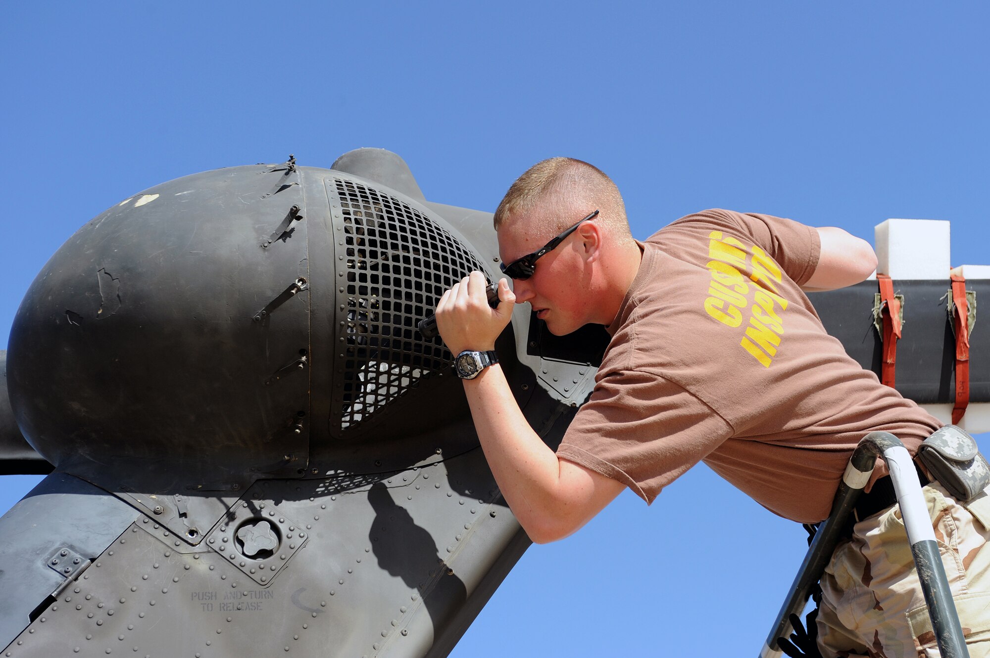 Petty Officer 3rd Class Levi Haguewood, a Navy Customs inspector, checks for dirt and grease in the tail components of an UH-60 Black Hawk helicopter at Joint Base Balad, Iraq, April 15, 2010. Customs personnel inspected 28 helicopters consisting of  AH-64 Apaches, CH-47 Chinooks and Black Hawks, to ensure they are clean and contain authorized equipment. The helicopters arrived from forward operating bases throughout Iraq and are being prepared for redeployment back to the United States. (U.S. Air Force photo by Master Sgt. Linda C. Miller/Released)  