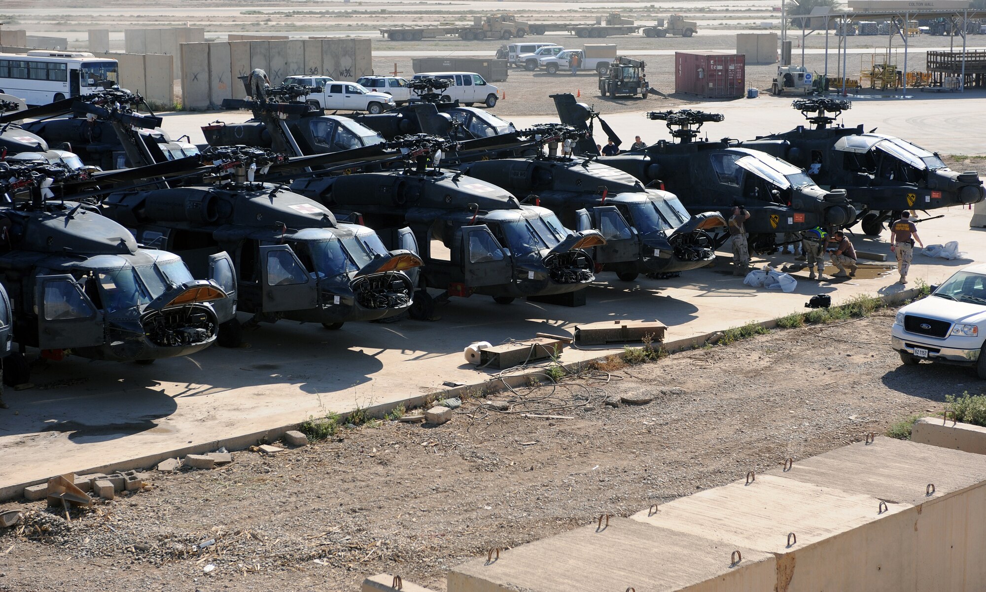 Navy Customs personnel begin inspecting a fleet of helicopters early in the morning at Joint Base Balad, Iraq, April 15, 2010. The 28 helicopters consisted of AH-64 Apaches, CH-47 Chinooks and UH-60 Black Hawks. Customs personnel will ensure they are clean and contain authorized equipment. The helicopters arrived from forward operating bases throughout Iraq and are being prepared for redeployment back to the United States. (U.S. Air Force photo by Master Sgt. Linda C. Miller/Released)