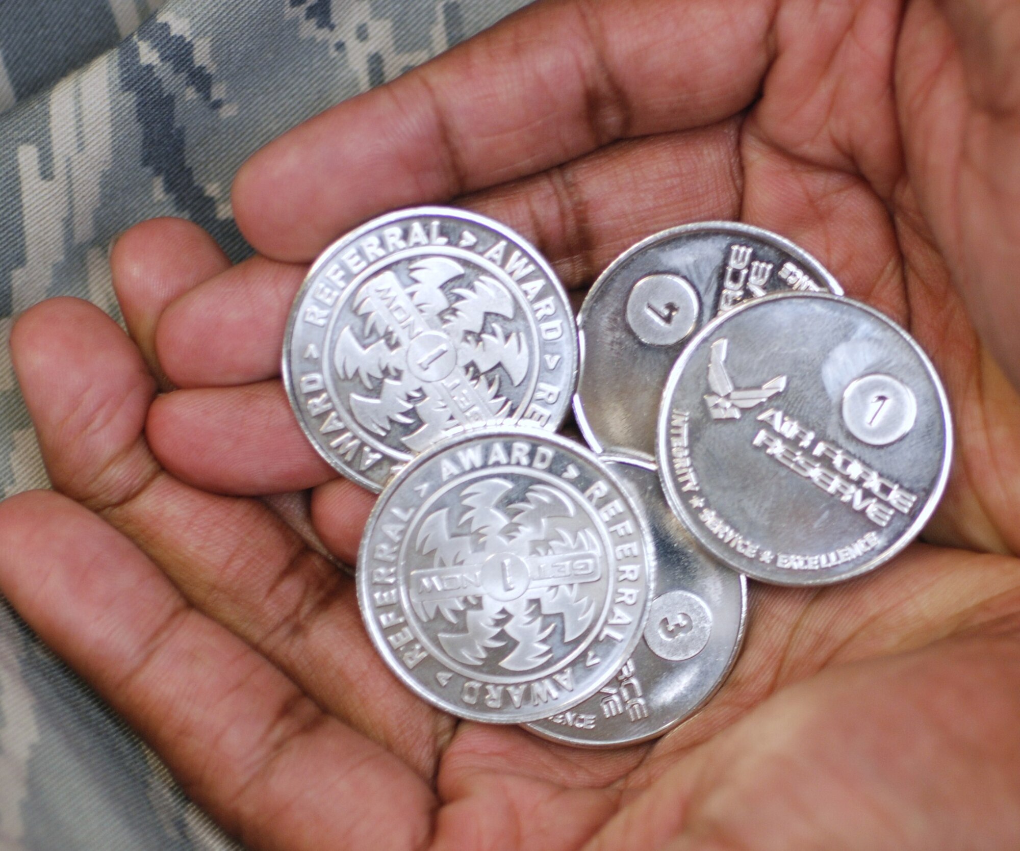 The Get One Now Program provides coins as thanks when service members provide referrals. (U.S. Air Force Photo by Timm Huffman)