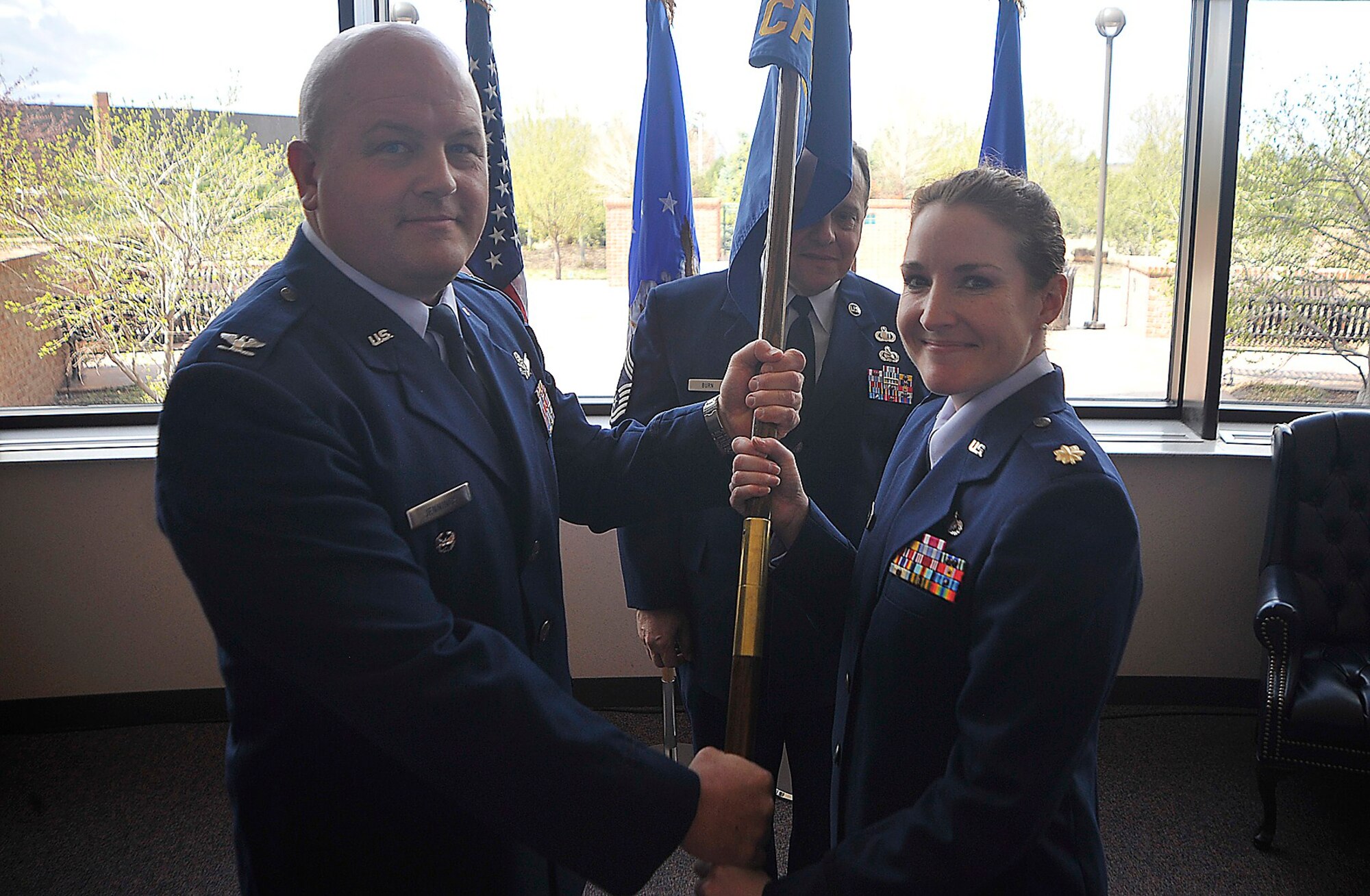 PETERSON AIR FORCE BASE, Colo. -- Col. Jim Jennings, 21st Space Wing vice commander, hands the 21st Comptroller Squadron flag to Maj. Patricia Borsos, interim 21st CPTS commander, April 19 at Building 350. The 21st CPTS’s mission is to push resources to space warfighters – financing unsurpassed installation support while providing combat ready warriors to defend America and its Allies. (U.S. Air Force photo/ Dennis Howk)
