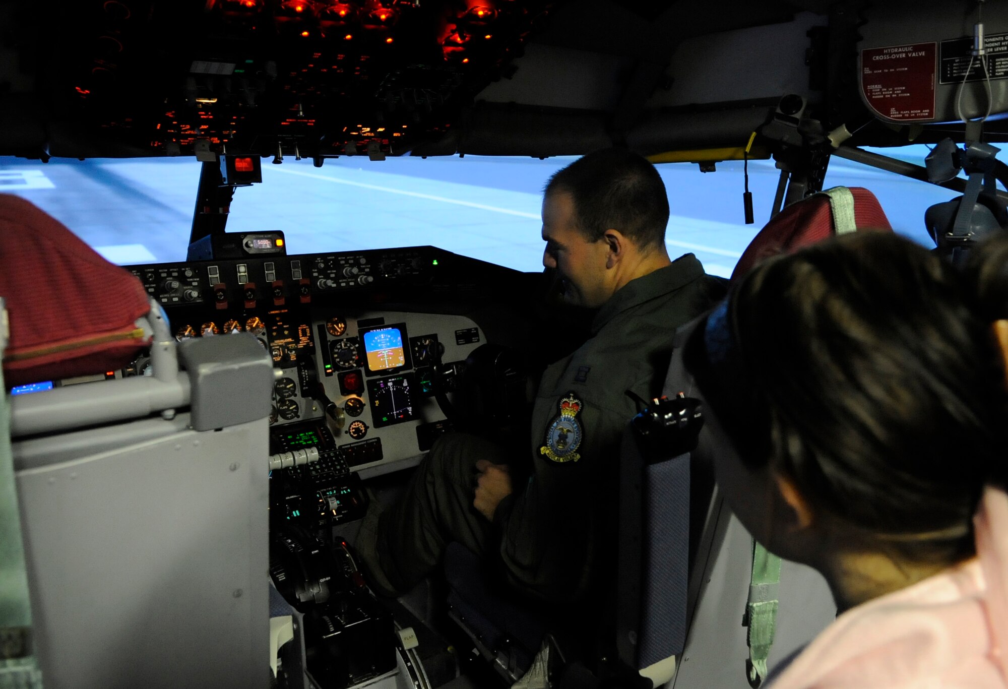 RAF MILDENHALL, England – Capt. Alex Waxman shows children how to operate a KC-135 Stratotanker simulator as part of “Bring Your Child to Work Day” April 22.  The event included several displays and got children to explore the world of being in the Air Force.  (U.S. Air Force photo/Staff Sgt. Christopher L. Ingersoll)