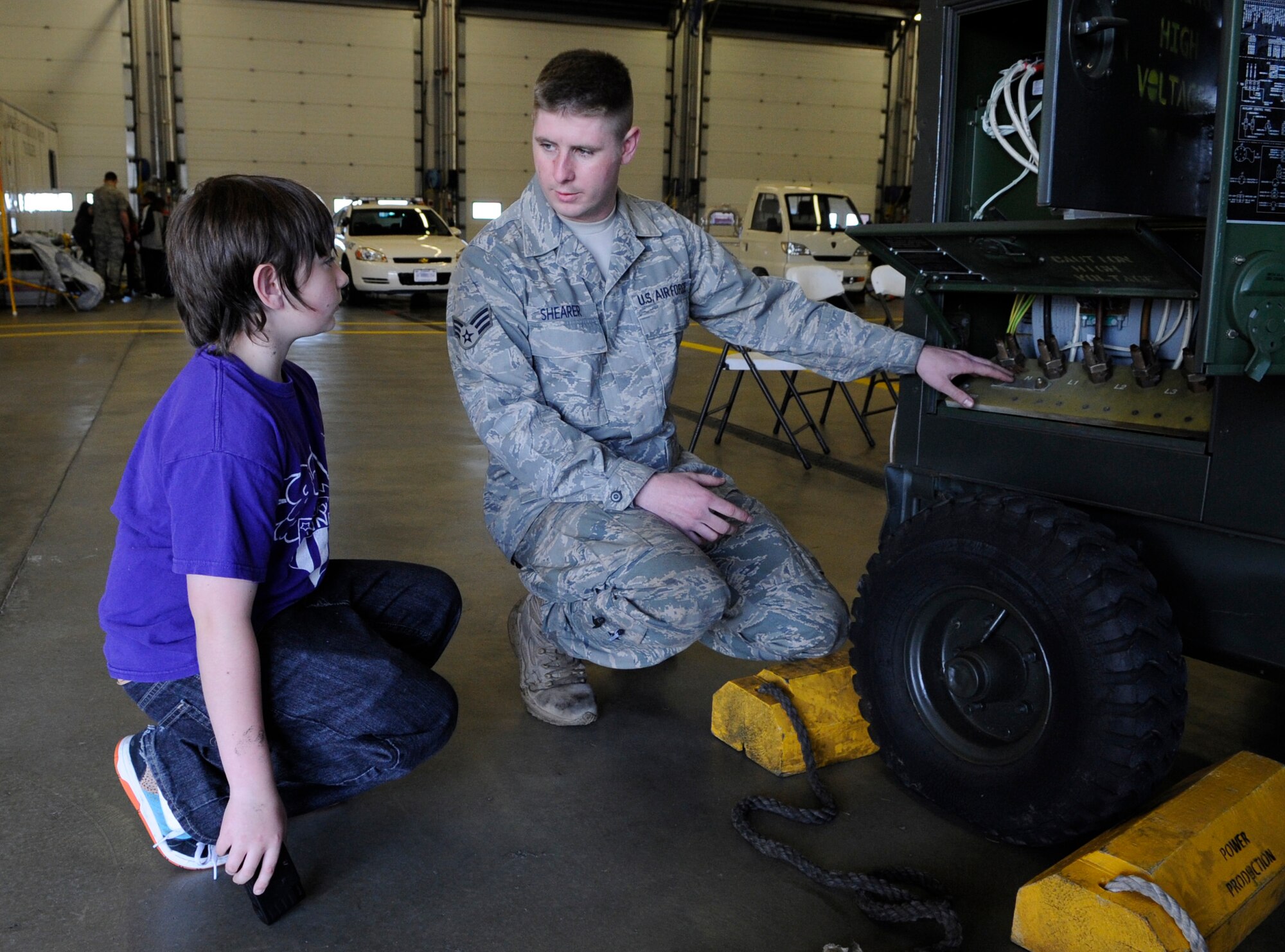 RAF MILDENHALL, England – Senior Airman Timothy Shearer, 100th Civil Engineer Squadron, shows Dylan Gribble the ins and outs of a mobile generator April 22.  The display was part of “Bring Your Child to Work Day.”  (U.S. Air Force photo/Staff Sgt. Christopher L. Ingersoll)
