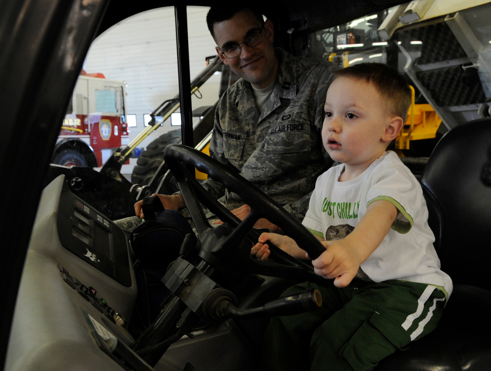 RAF MILDENHALL, England – Capt. Lance Ratterman, 100th Air Refueling Wing, and his son Nolan try out construction equipment during “Bring Your Child to Work Day” April 22.  The event included several displays of heavy equipment, aircraft and even a spin on the KC-135 Stratotanker flight simulator.  (U.S. Air Force photo/Staff Sgt. Christopher L. Ingersoll)