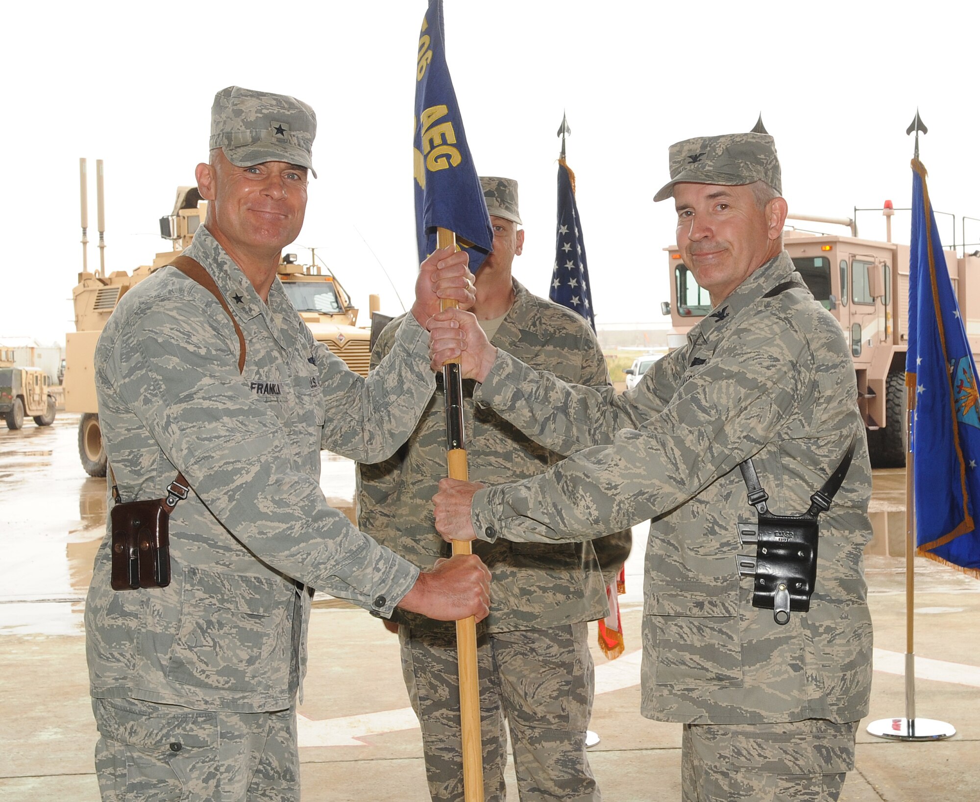 Brig. Gen. Craig Franklin, 332nd Air Expeditionary Wing commander, passes a guidon to Col. Steven Slick, incoming 506th Air Expeditionary Group commander, during the 506 AEG change of command ceremony at Kirkuk Regional Air Base, Iraq on April 22, 2010.  Col. Slick replaced Col. Leonard Dick as the AEG commander. The ceremony was attended by Iraqi Air Force members, mission partners from the Iraq Training and Advisory Mission – Air Force, and the men and women of the 506th AEG.  (U.S. Air Force photo/Staff Sgt. Tabitha Kuykendall/Released)	 	