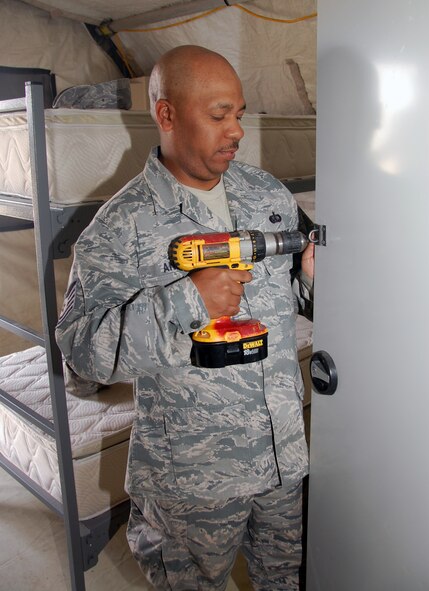 U.S. Air Force Tech. Sgt. Willie Andino, 386th Expeditionary Force Support Squadron Commando Village lodging assistant manager, secures a lock on a wall locker in a transient tent April 19, 2010 at an air base in Southwest Asia. (U.S. Air Force photo by Tech. Sgt. Lindsey Maurice/Released)