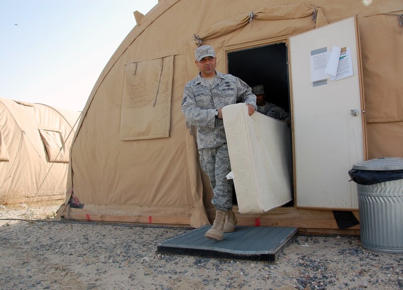 U.S. Air Force Staff Sgt. Scott Alarcon and Tech. Sgt. Willie Andino, both of the 386th Expeditionary Force Support Squadron Commando Village lodging staff, move a mattress from a storage tent April 19, 2010 at an air base in Southwest Asia. (U.S. Air Force by Tech. Sgt. Lindsey Maurice/Released)