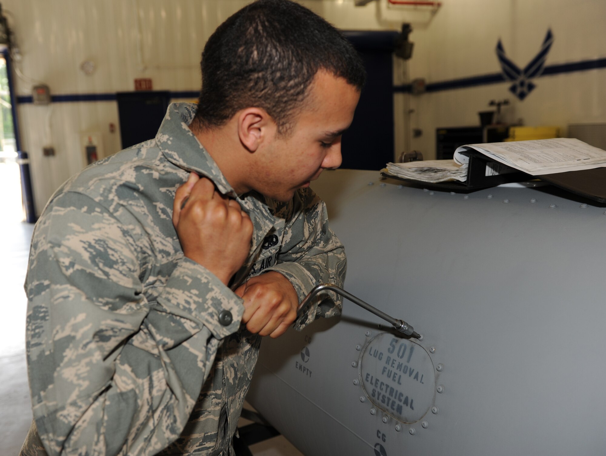 SEYMOUR JOHNSON AIR FORCE BASE -- Airman Anwar Fikri removes a panel from a 600-pound external fuel tank for inspection here April 20, 2010. External fuel tanks have annual inspections to ensure serviceability, if found unserviceable the tanks will either be fixed or replaced. Airman Fikri, 4th Component Maintenance Squadron Aircraft fuel systems apprentice, hails from Rockville, Md. (U.S. Air Force photo by Airman 1st Class Gino Reyes)