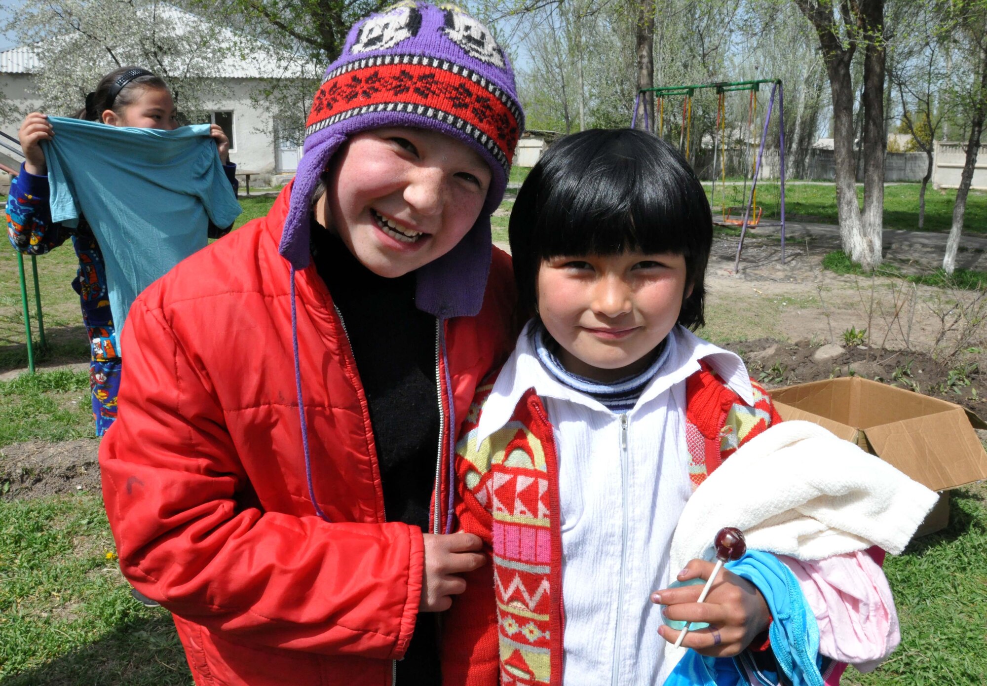 Two Kyrgyz girls from the Orto-Suiskaya Boarding School/orphanage for children delight in their new clothing from the Transit Center at Manas, Kyrgyzstan, April 22, 2010. Airmen delivered food and clothing to the residents there as a part of their ongoing humanitarian assistance mission. (U.S. Air Force photo/Staff Sgt. Carolyn Viss)