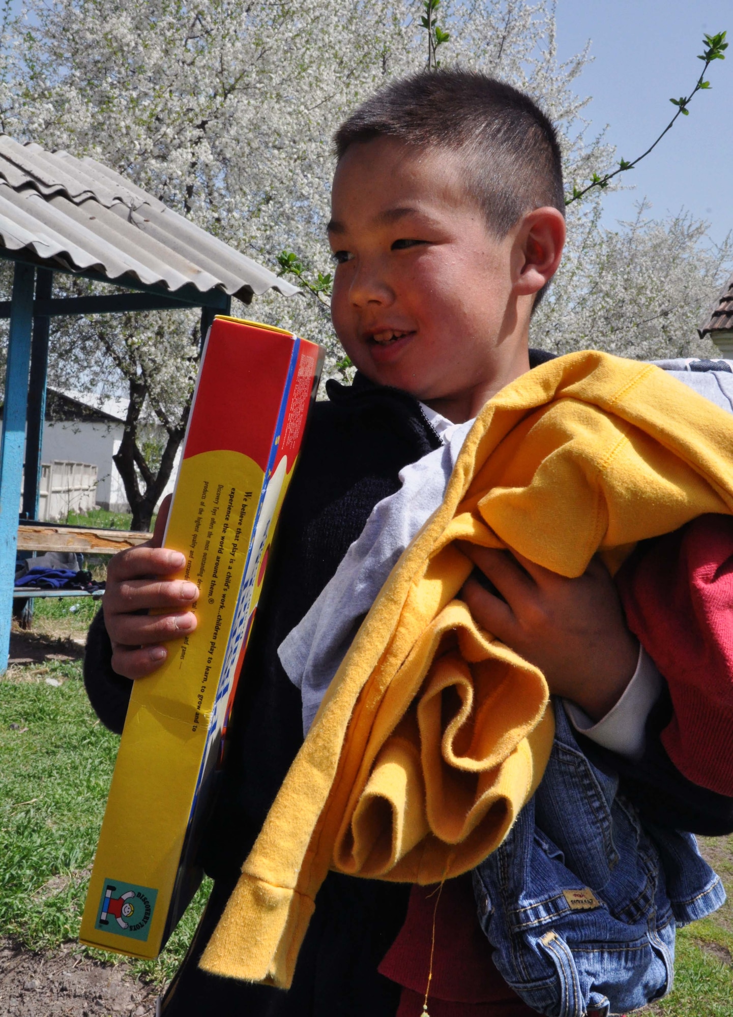 A Kyrgyz boy from the Orto-Suiskaya Boarding School/orphanage for children delights in his new clothing from the Transit Center at Manas, Kyrgyzstan, April 22, 2010. Airmen delivered food and clothing to the residents there as a part of their ongoing humanitarian assistance mission. (U.S. Air Force photo/Staff Sgt. Carolyn Viss)