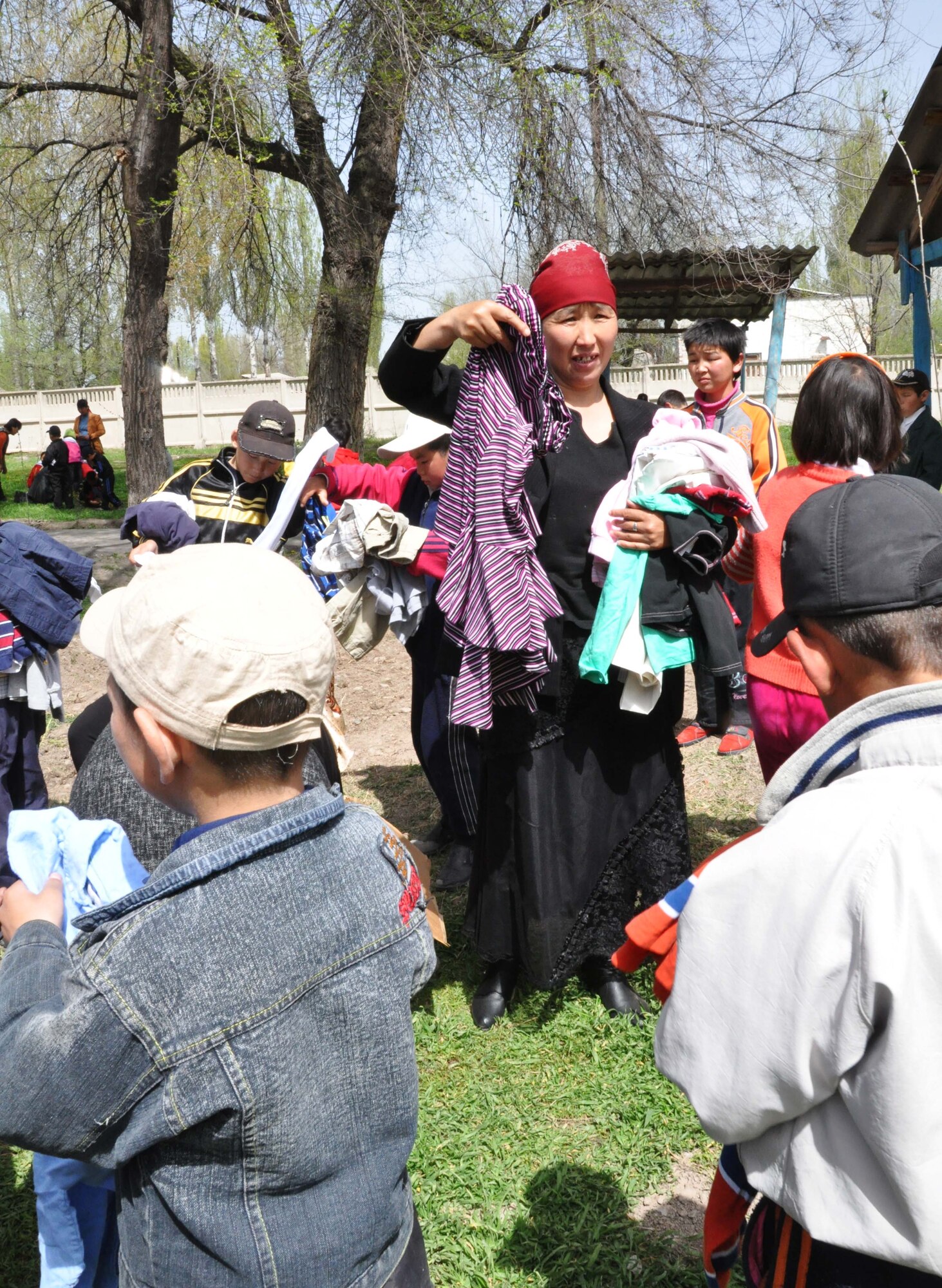 A staff member at the Orto-Suiskaya Boarding School/orphanage for children offers different sizes of clothing to some of the 180 residents there April 22, 2010. Airmen from the Transit Center delivered food and clothing to the residents there as a part of their ongoing humanitarian assistance mission. (U.S. Air Force photo/Staff Sgt. Carolyn Viss)