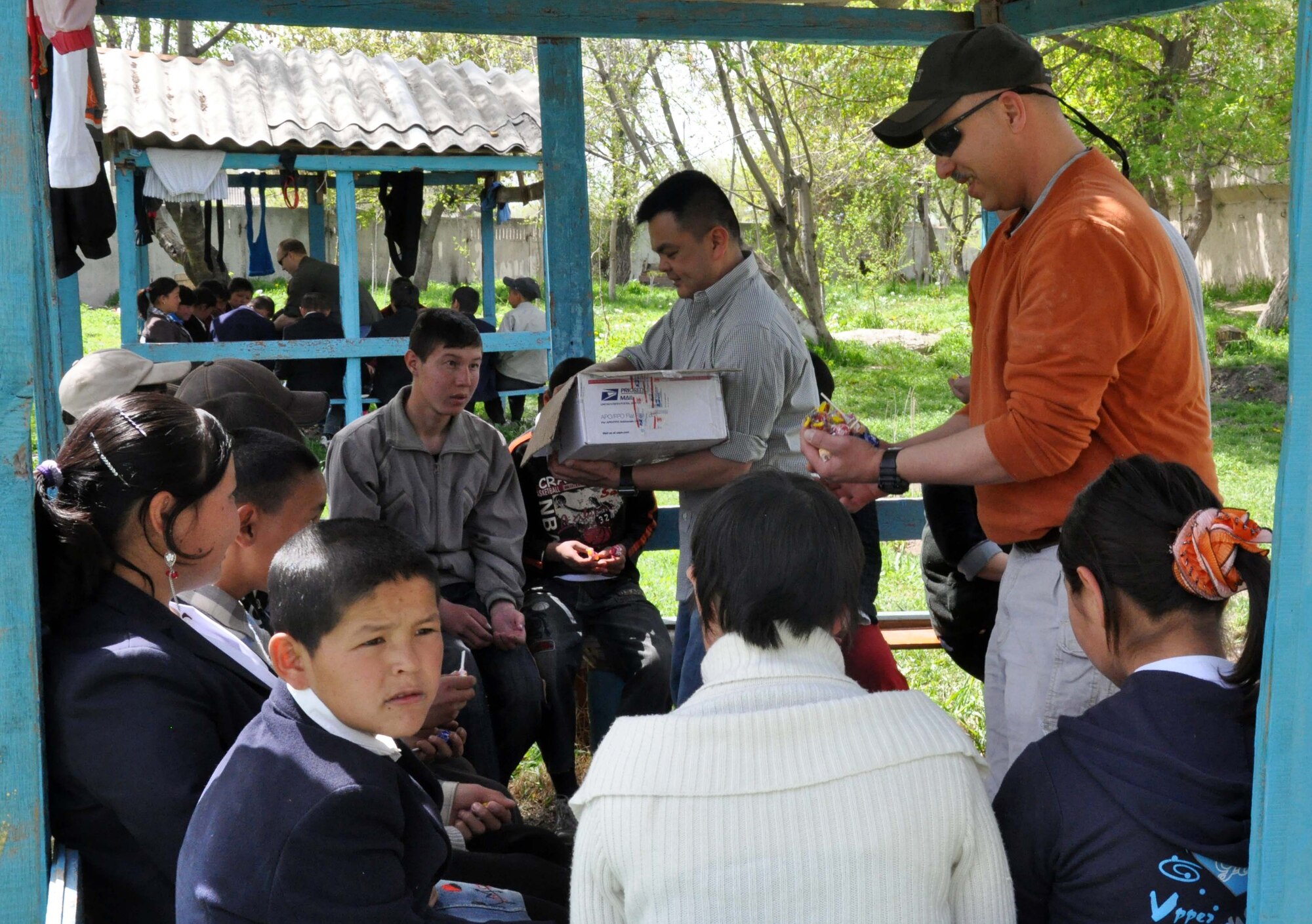 Capt. Tom Mulka and Tech. Sgt. Don Tipton Jr., Airmen from the Transit Center at Manas, Kyrgyzstan, hand out candy at the Orto-Suiskaya Boarding School/orphanage for children with mental disabilities April 22, 2010. Humanitarian assistance is an important focus for Airmen from the Transit Center. (U.S. Air Force photo/Staff Sgt. Carolyn Viss)