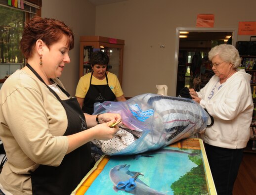 SEYMOUR JOHNSON AIR FORCE BASE, N.C. -- Debbie Jones clips the price tag off a comforter before selling it to a customer here, April 20, 2010. Ms. Jones, a native of Chicago, has been a volunteer here for more than three and a half years. (U.S. Air Force photo/Senior Airman Whitney Lambert)