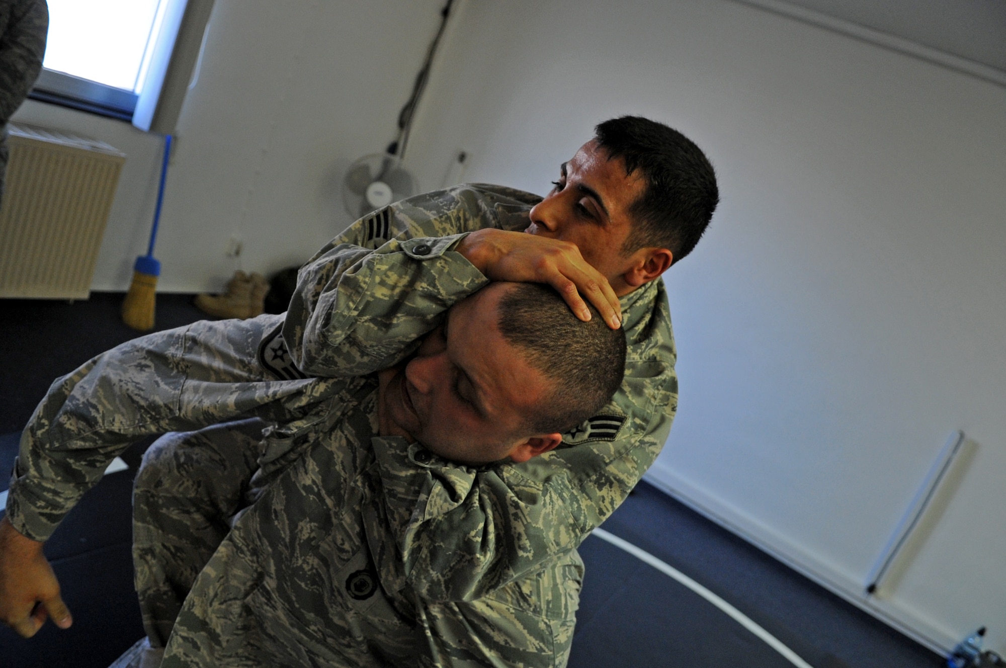 U.S. Air Force Senior Airman Antonio Padilla chokes Staff Sgt. Thomas Morris, both from the 569th Security Forces Squadron, during a modified army combative practice session, Sembach Annex, Germany, April 21, 2010. The army combative course was part of Unites States Air Forces in Europe's first ever Fly Away Security Team class. (U.S. Air Force photo by Airman 1st Class Grovert Fuentes-Contreras)