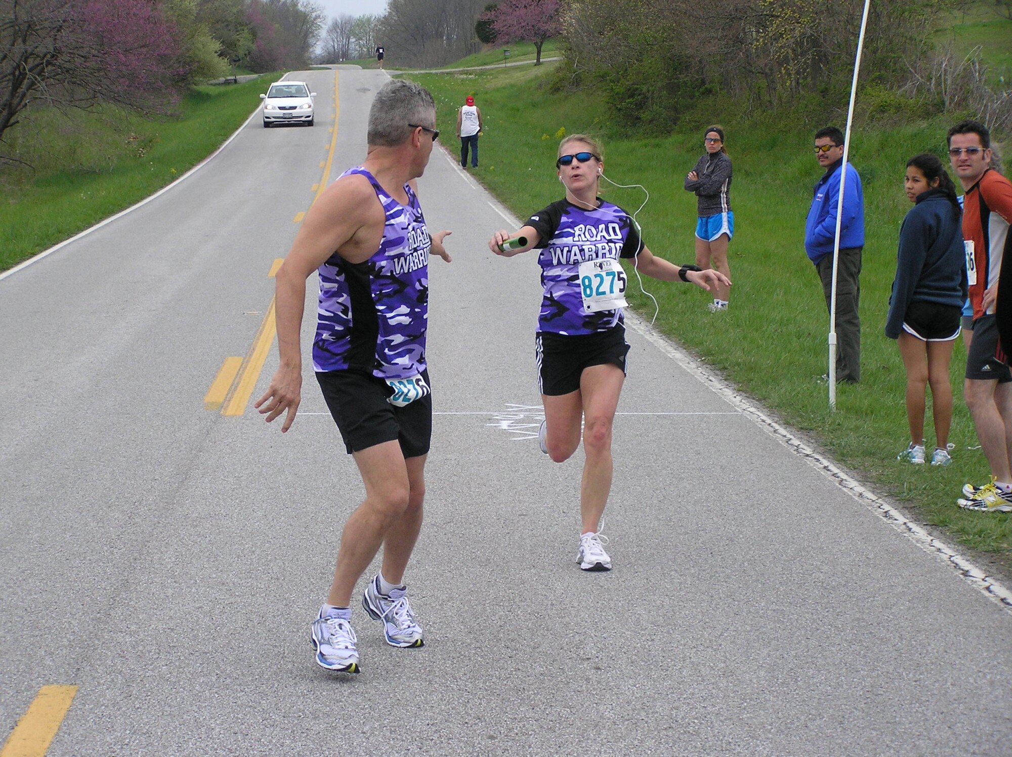 SCOTT AIR FORCE BASE, Ill. -- Tami Spellman passes the relay baton to Mark Atkins during a race.  They are both members of the Road Warriors club. (Courtesy Photo)