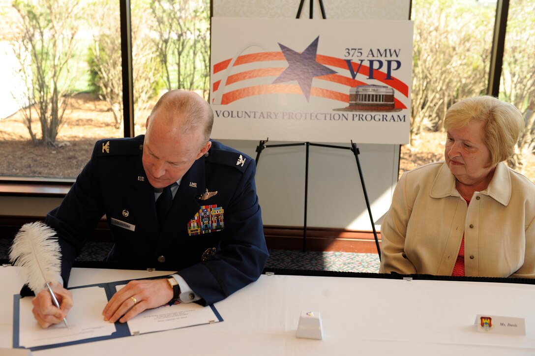 Col. Gary Goldstone, 375th Air Mobility Wing commander, signs the order for the new Voluntary Protection Program April 13 in the Scott Club with Judy Davis, National Association of Government Employees R7-23 president. The VPP is a comprehensive safety and health management system meant to create a safer work place for all 375th AMW members.(U.S. Air Force photo by Senior Airman Wesley Farnsworth)
