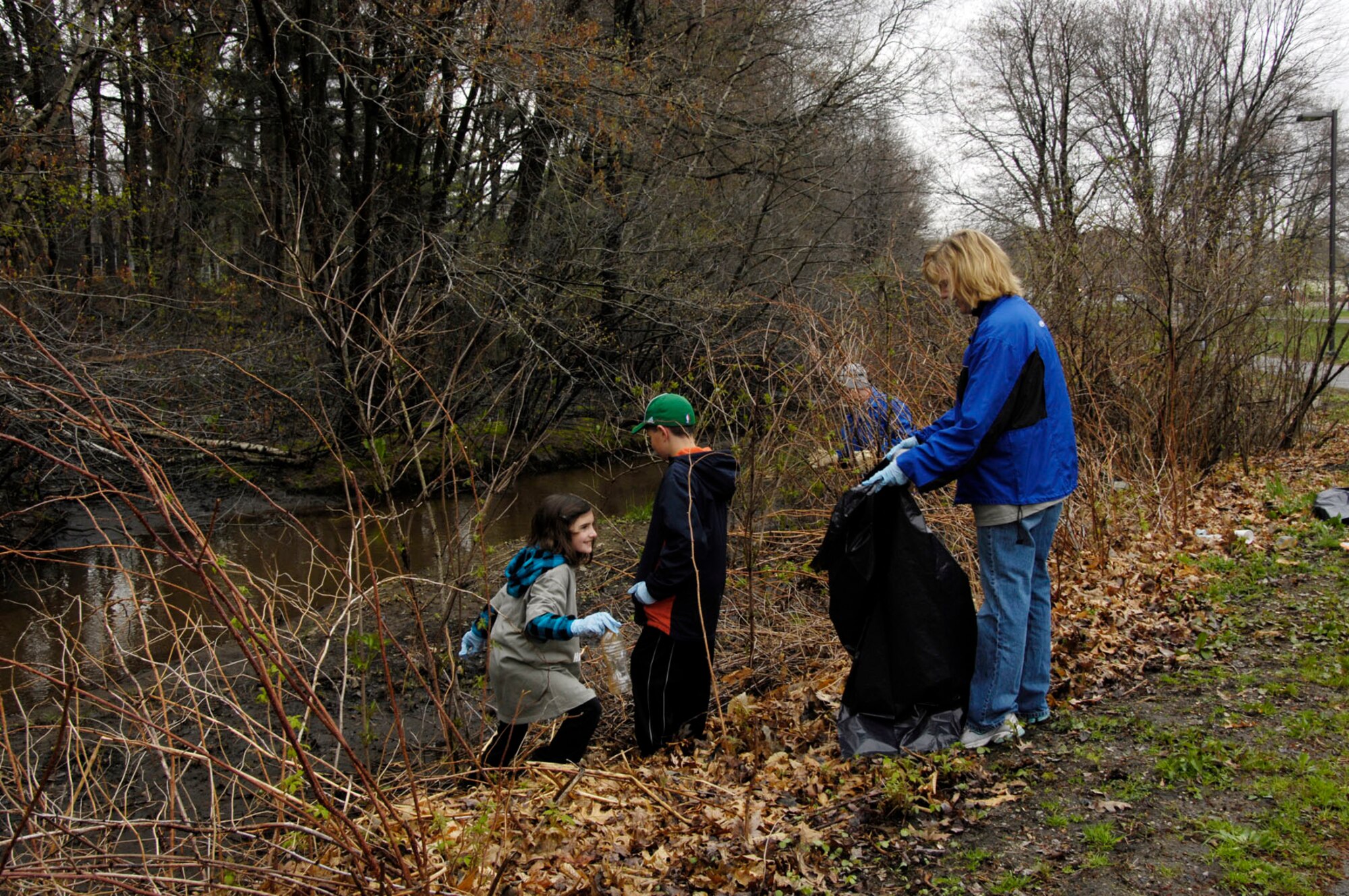 HANSCOM AIR FORCE BASE, Mass - Sue Panocoplus and her children, Katie and Matt, remove trash from the Shawsheen River as part of the Earth Day 2010 celebrations on base. The environmental office hosted the 10th annual river clean up on April 16. (U.S. Air Force photo by Linda LaBonte Britt)
