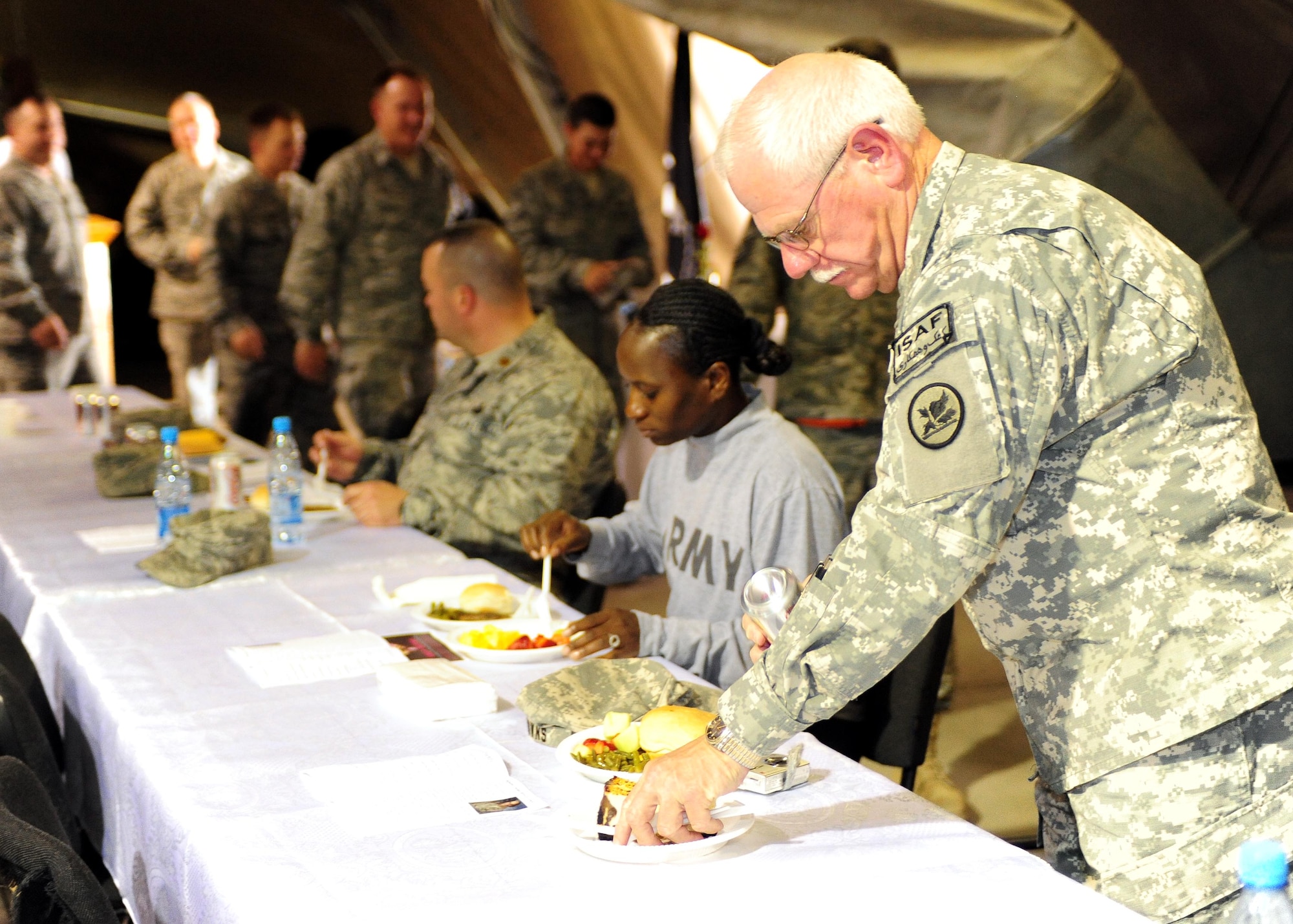 U.S. military service members sit down for a bite to eat during the National Prayer Luncheon at the Transit Center at Manas, Kyrgyzstan, April 21, 2010. U.S. Air Forces Central Command Chaplain, Col. Jerry Lewis, presided over the ceremony. (U.S. Air Force photo/ Senior Airman Nichelle Anderson/ released)