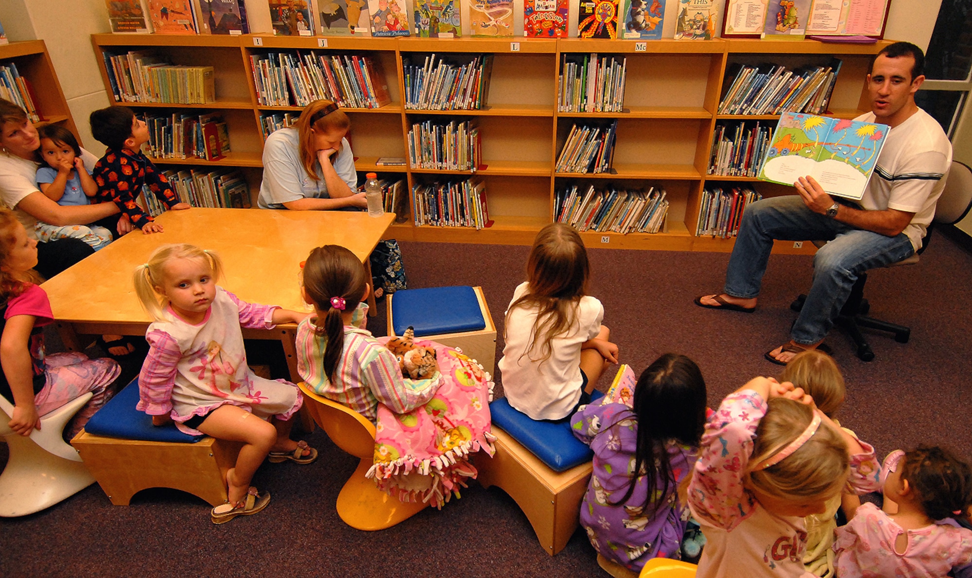 Second Lt. Phil Collins, 718th Civil Engineer Squadron, reads Dr. Seuss' "The Lorax" during an Earth Week pajama storytime party at the Kadena Library April 21. More than a dozen children learned about Earth Week, recycling and energy conservation as four Kadena volunteers read children's books relating to Earth Day.  The event kicked off a series of events scheduled throughout the week celebrating the 40th anniversary of Earth Day. (Air Force/Staff Sgt. Jason Lake)