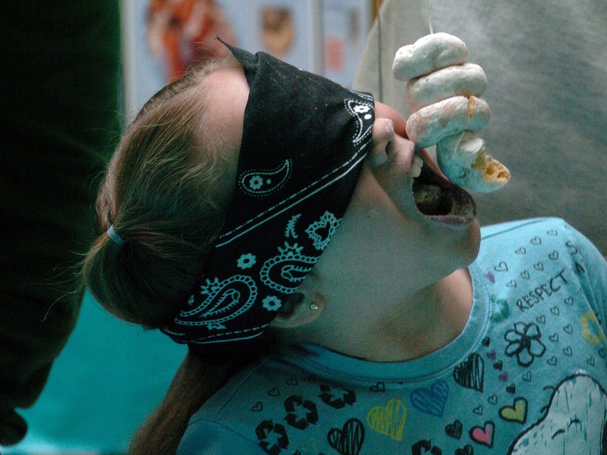 YOKOTA AIR BASE, Japan -- Kayla Mindel, 3rd Grader, tries to devour all four of the donuts in front of her during the "Take a bite out of Crime" donut eating competition here April 17. The competition was held as a way to raise awareness about sexual assault. (U.S. Air Force photo/Airman 1st Class Katrina R. Menchaca)