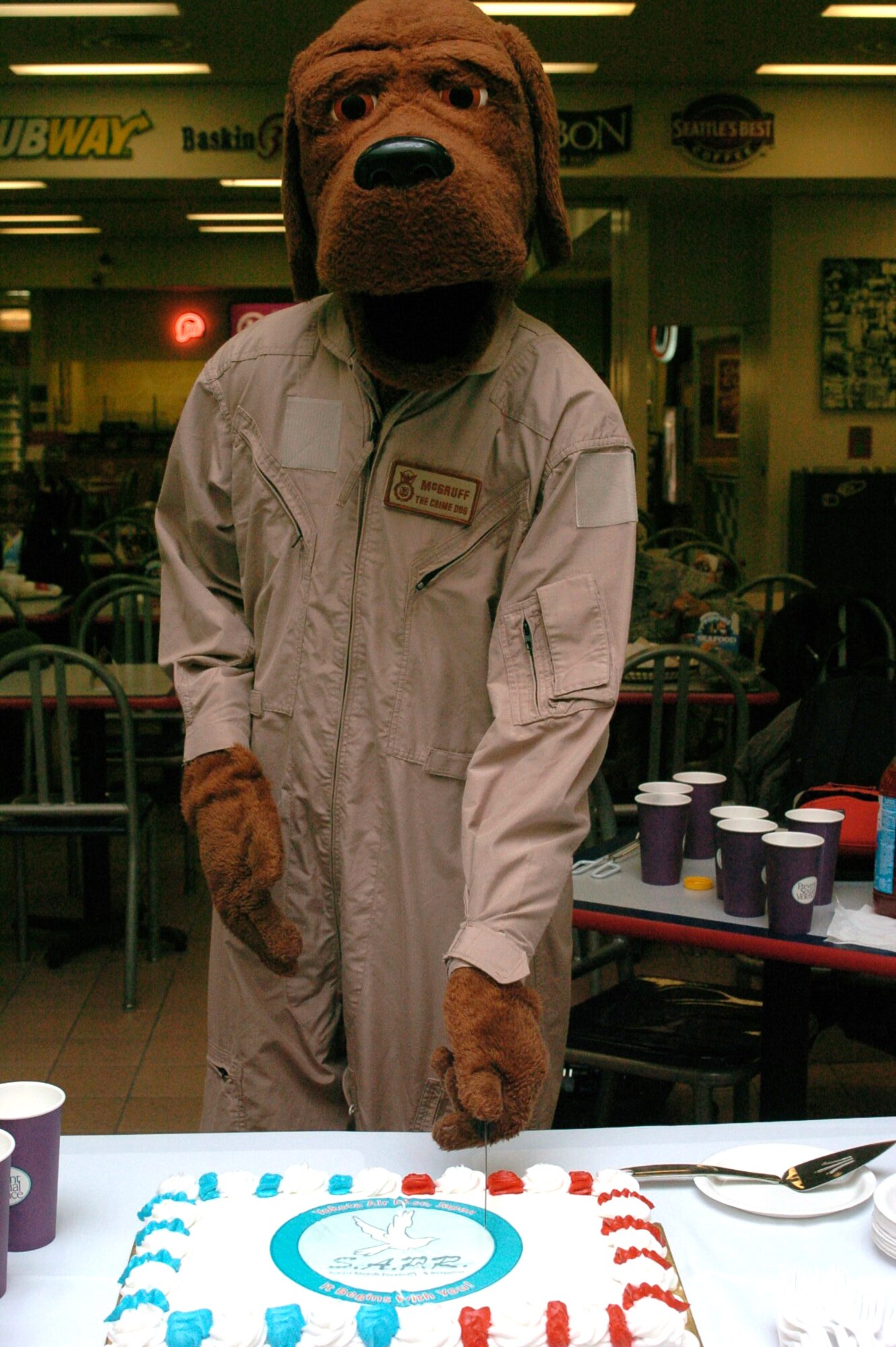 YOKOTA AIR BASE, Japan -- McGruff the Crime Dog cuts the Sexual Assault Response and Prevention cake at the "Take a bite out of Crime" donut eating competition here April 17. The competition was held as a way to raise awareness about sexual assault. (U.S. Air Force photo/Airman 1st Class Katrina R. Menchaca)