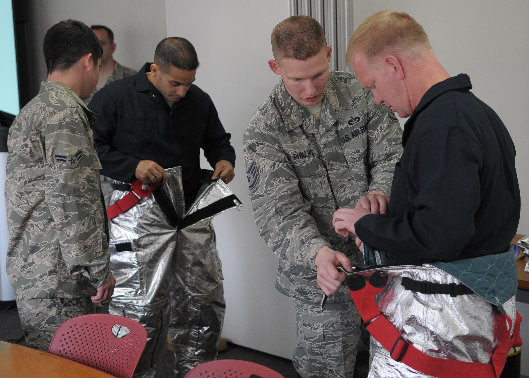 YOKOTA AIR BASE, Japan -- Col. Mark Hicks, 374th Airlift Wing commander, and Chief Master Benjamin Caro, 374th Airlift Wing command chief, put on their Personal Protective Equipment April 20 during a live fire training exercise.  (U.S. Air Force photo/Airman 1st Class Sean Martin)